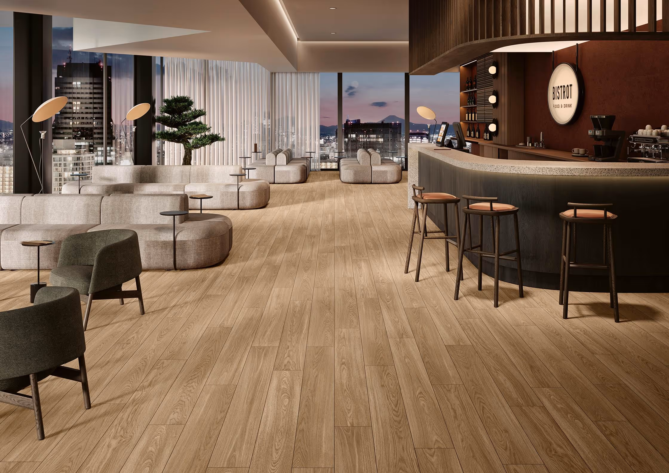 Modern lounge with beige modular sofas, green chairs, wooden floor, bar area, and city view at dusk.