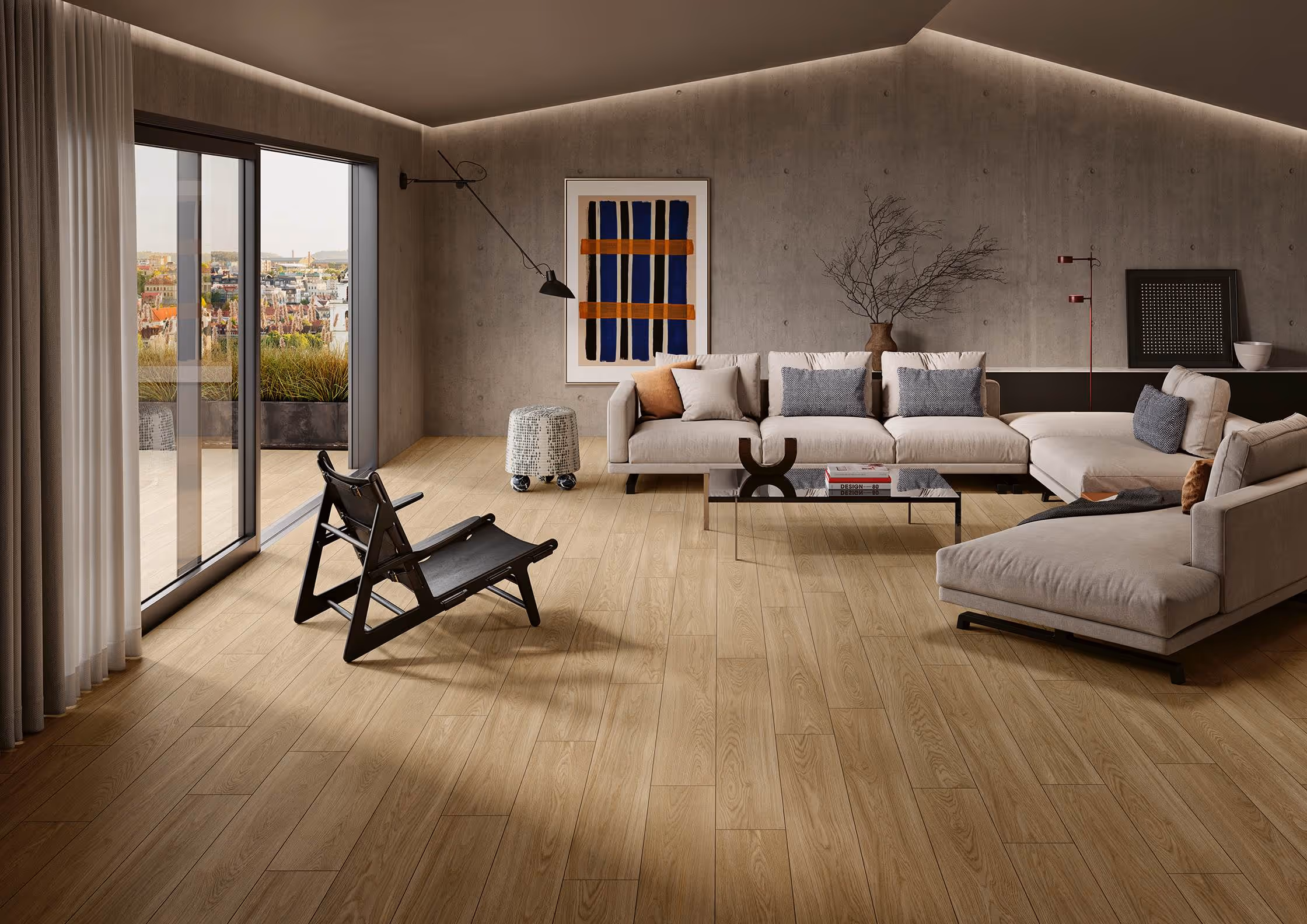 Modern living room with beige sectional sofa, black chair, wooden flooring, and city view through glass doors.