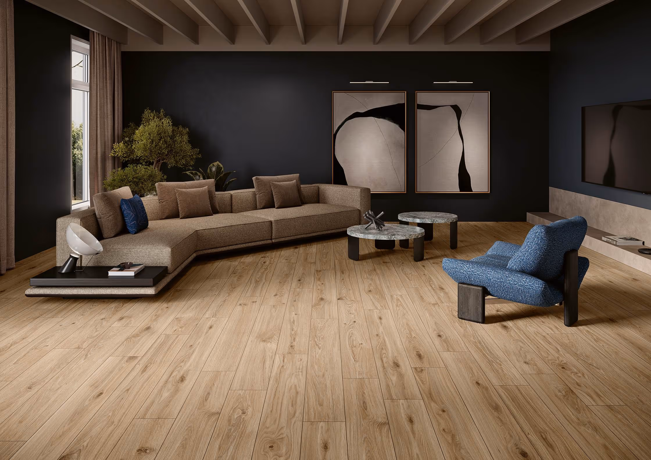 Modern living room with beige sectional sofa, blue armchair, round tables, wood floor, and abstract wall art.