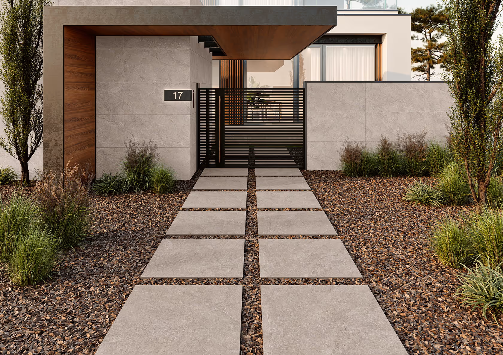 Modern house entrance with gray concrete stepping stones, gravel landscaping, and a black metal gate.
