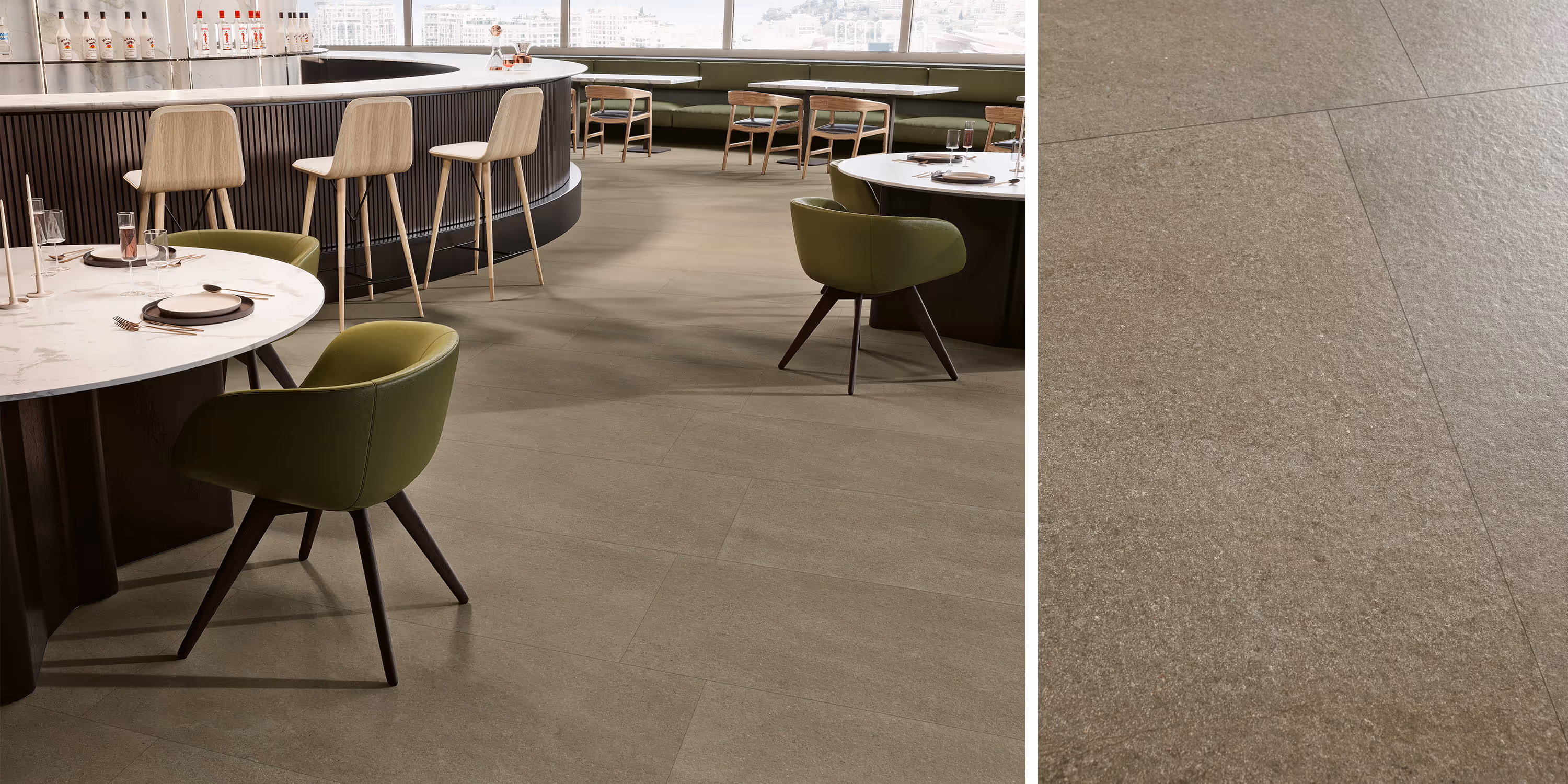 Modern dining area with round tables, green chairs, wooden bar stools, and textured beige floor tiles.
