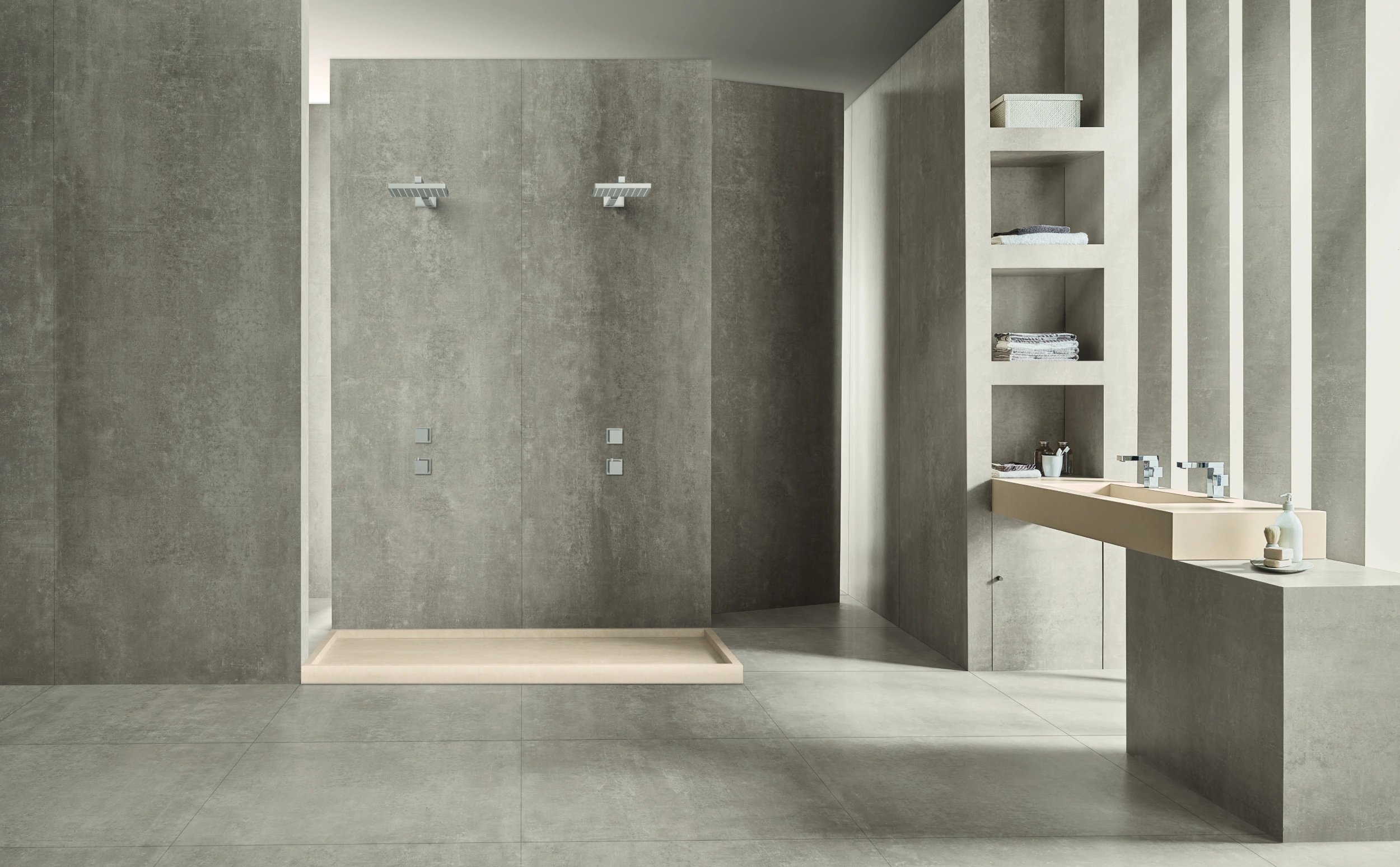 Modern bathroom with dual shower heads, beige double sink, and built-in shelves with towels and toiletries.