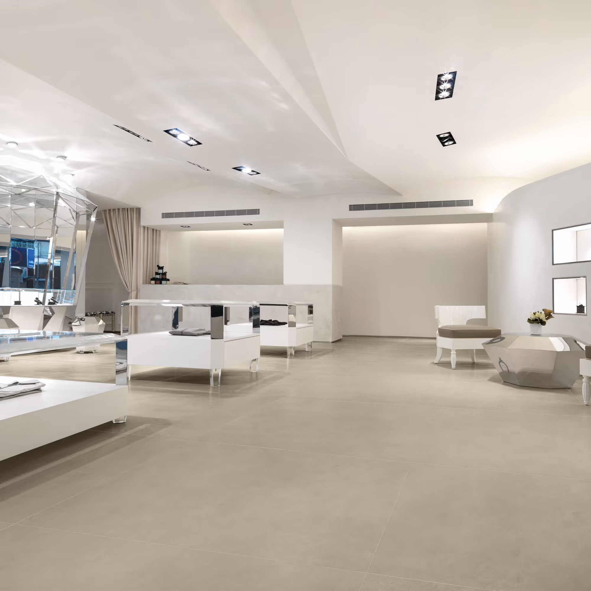 Minimalist modern interior with white furniture, reflective surfaces, and beige tile flooring.