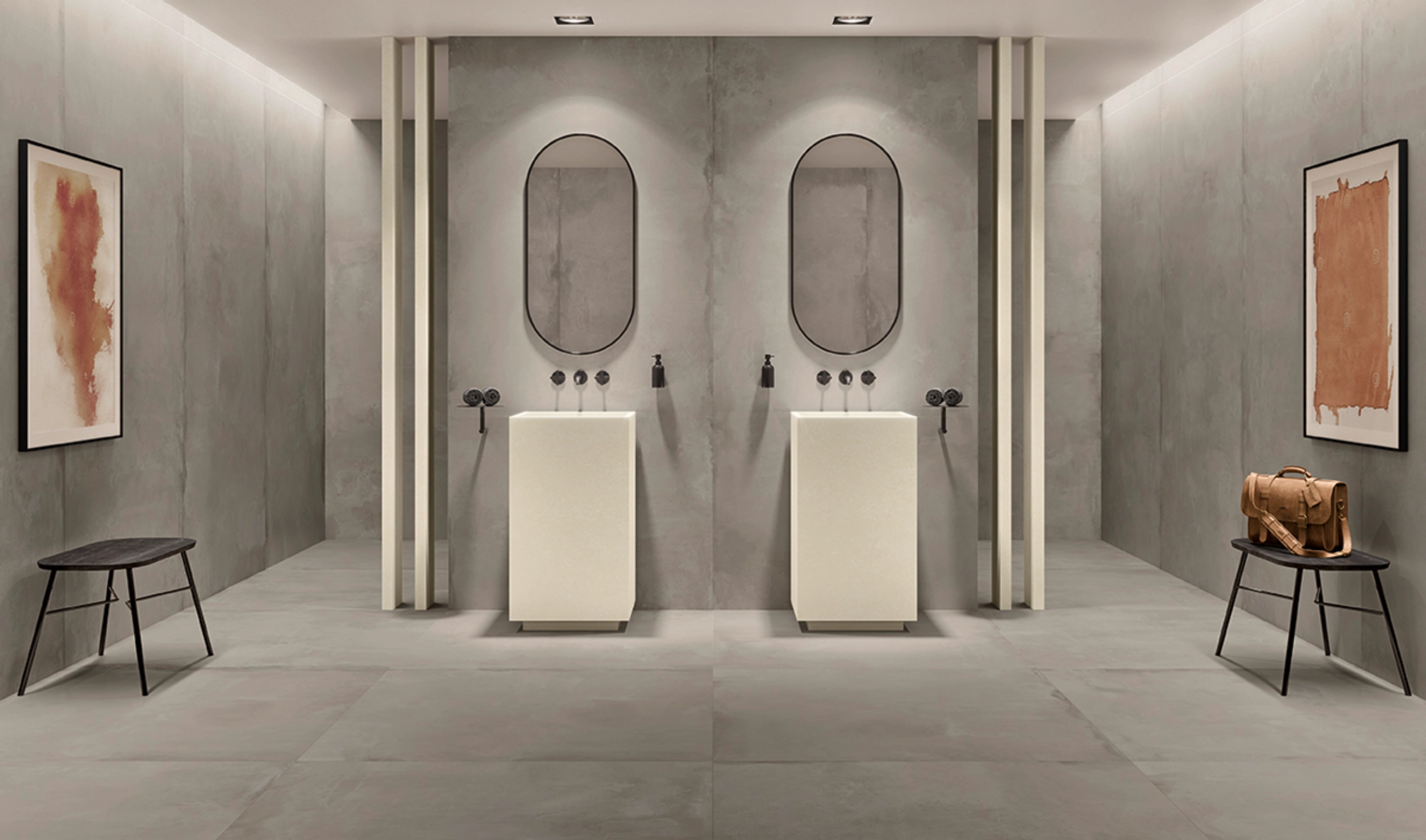 Modern minimalist bathroom with two pedestal sinks, oval mirrors, benches, and abstract wall art.