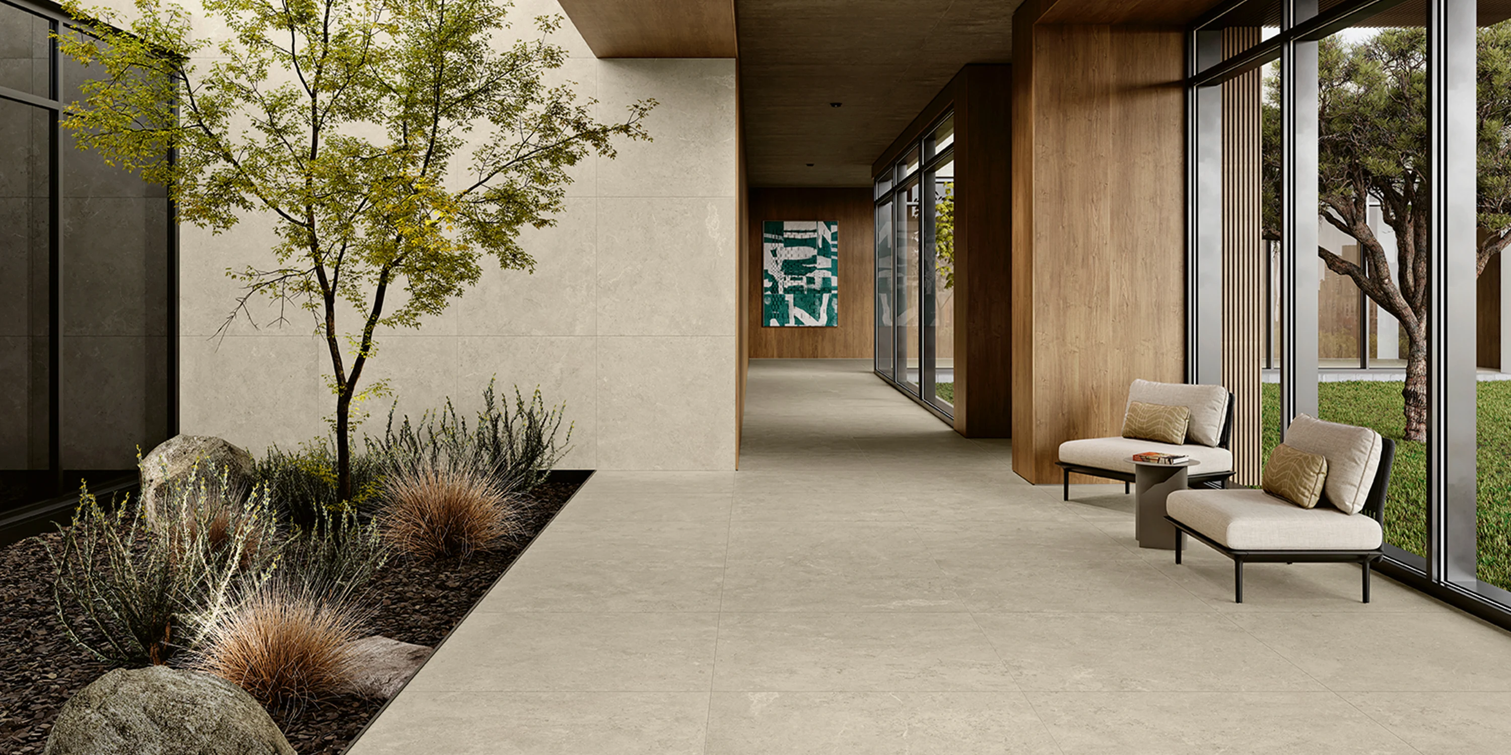 Modern indoor space with stone tile floor, plants in planter, two cushioned chairs, and large windows.