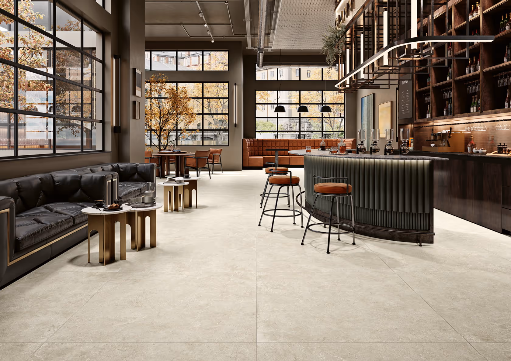 Modern bar interior with black leather sofas, round tables, bar stools, and large industrial windows.