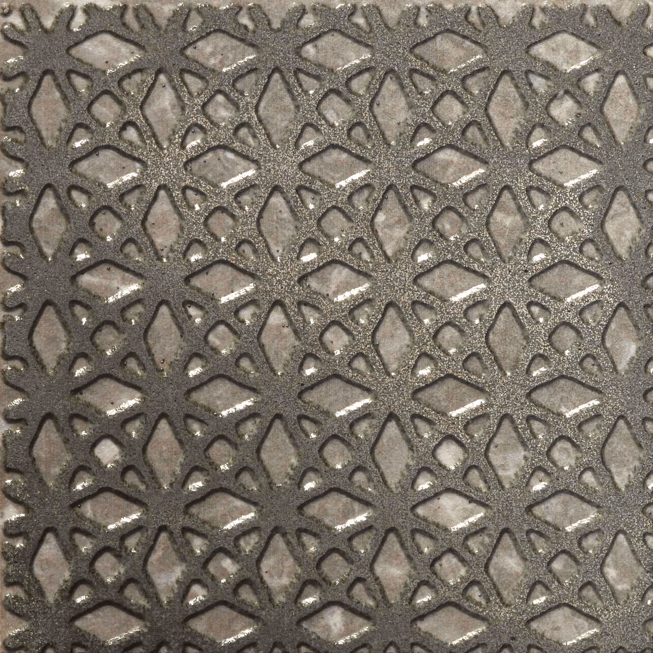 Close-up of beige stone tile with textured silver-gray geometric lattice pattern overlay.
