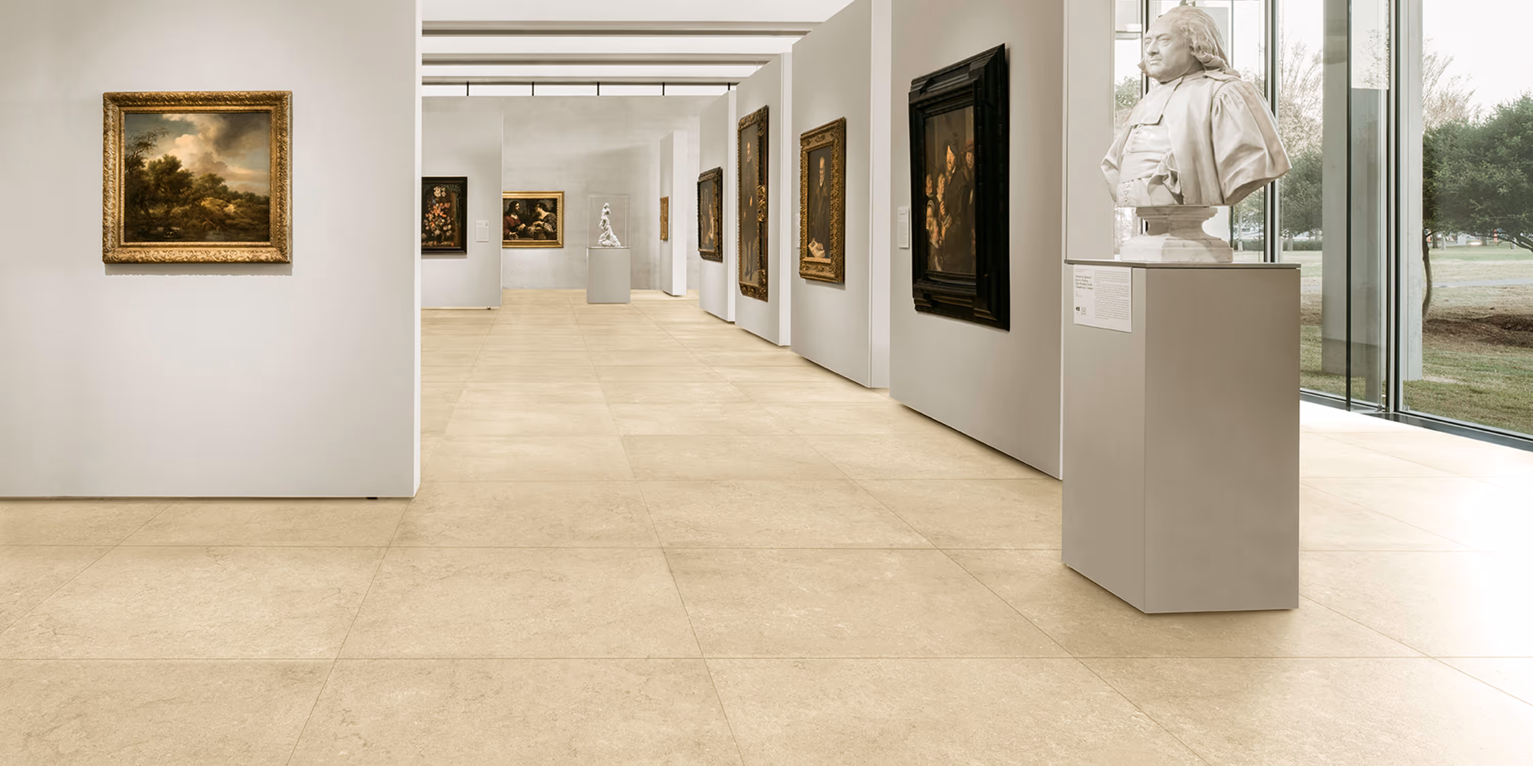 Gallery room with beige tiled floor, white walls displaying paintings, and a marble bust on a pedestal.