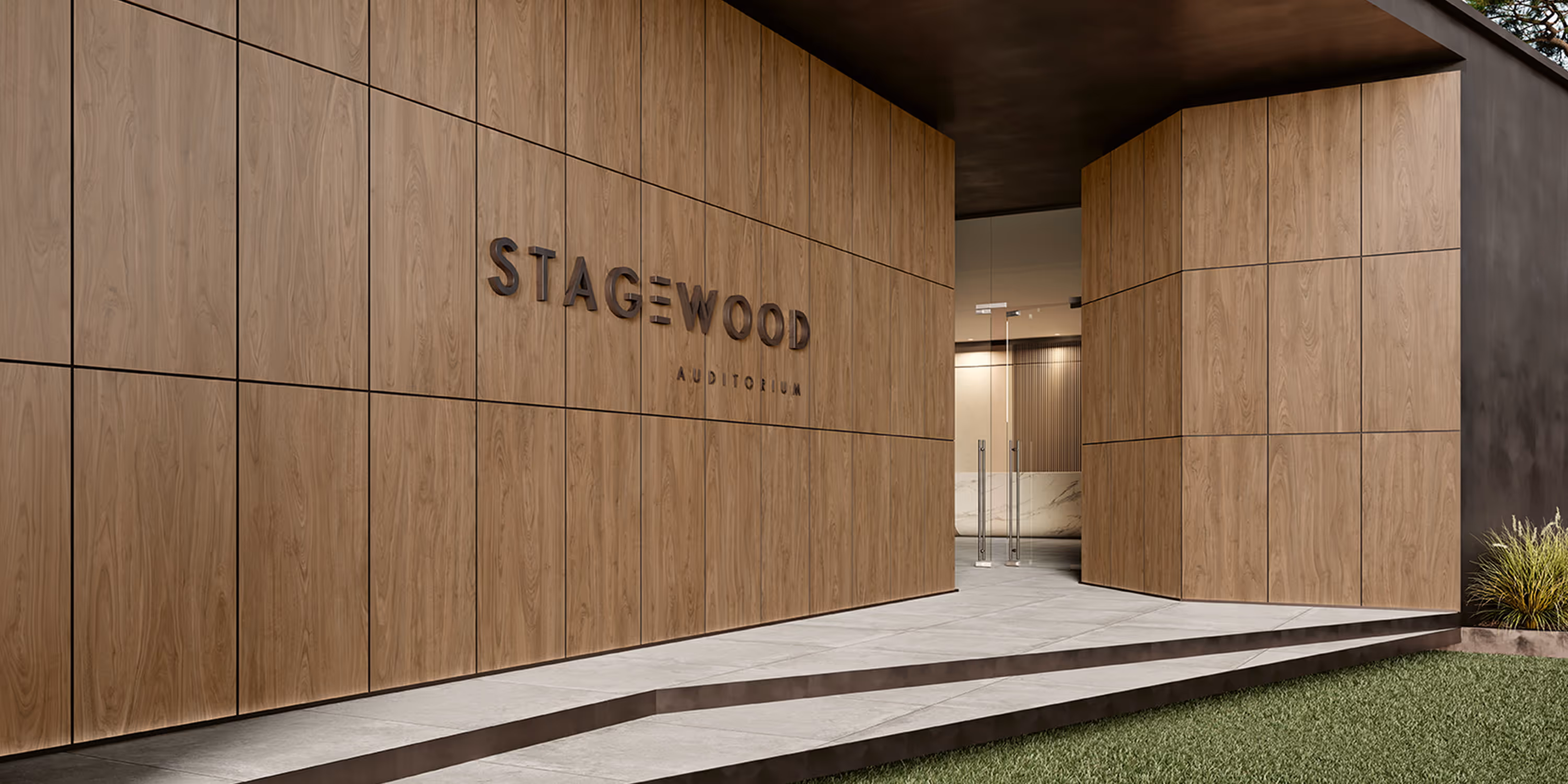 Modern auditorium entrance with wooden paneled walls and glass doors, labeled Stagewood Auditorium.