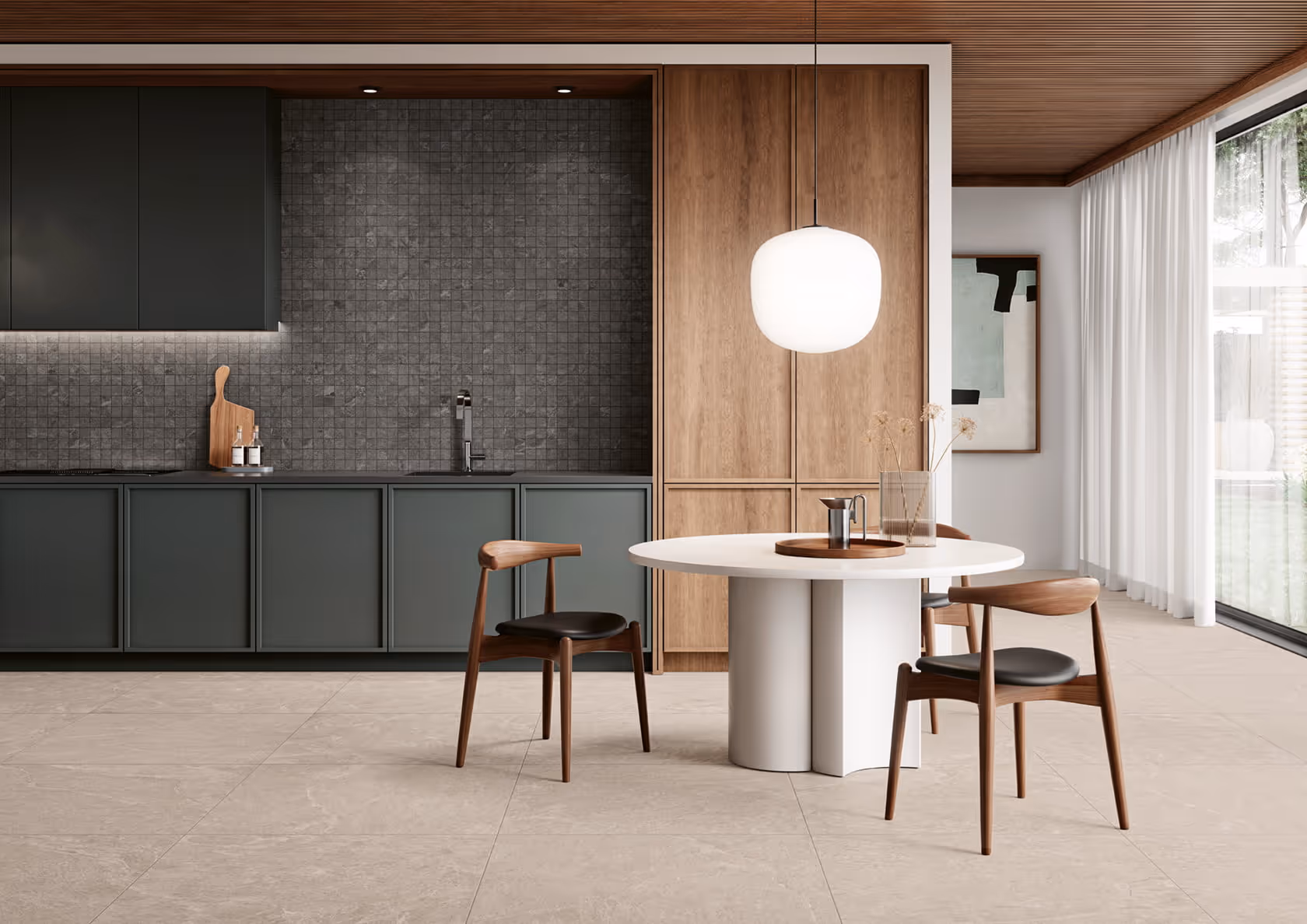 Modern kitchen with dark cabinets, tiled backsplash, round white table, wooden chairs, and pendant light.