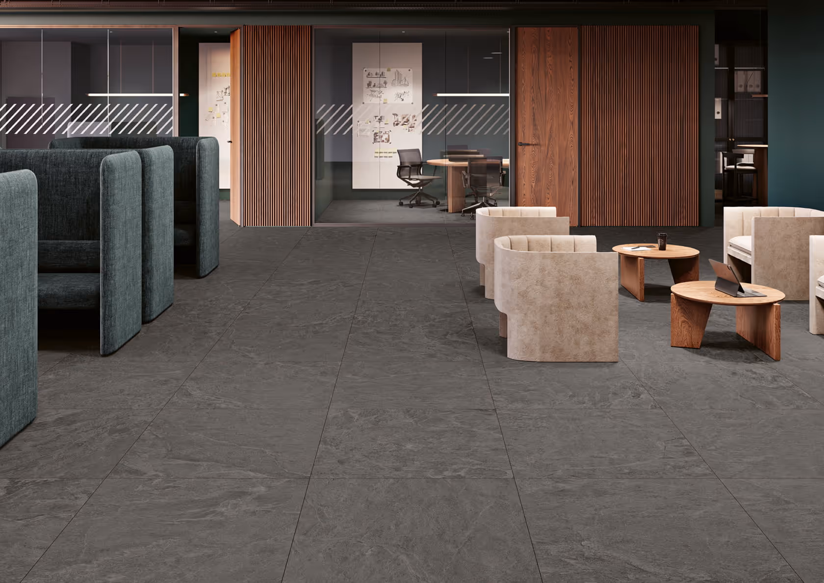 Modern office lounge with beige armchairs, wooden tables, and glass-walled meeting rooms in the background.