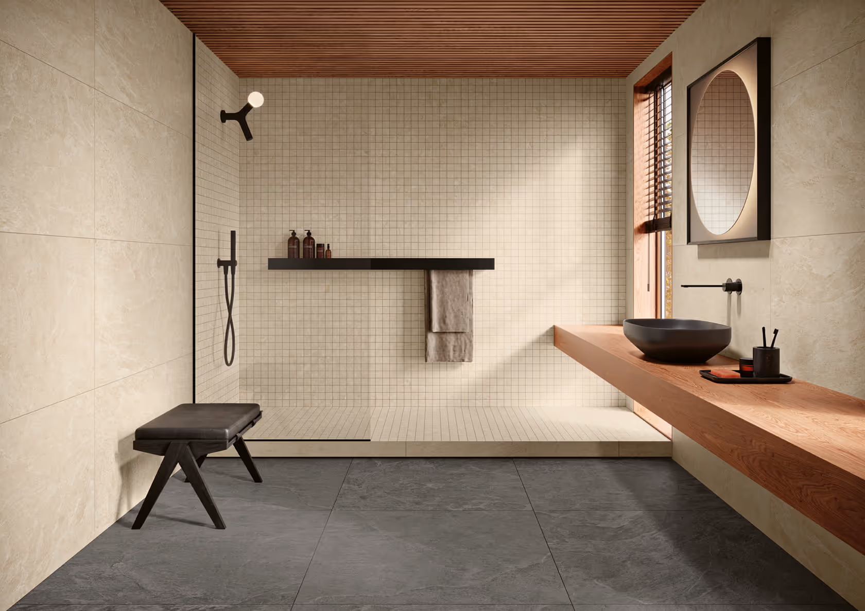 Modern bathroom with walk-in tiled shower, black stool, wooden floating vanity, and round mirror.