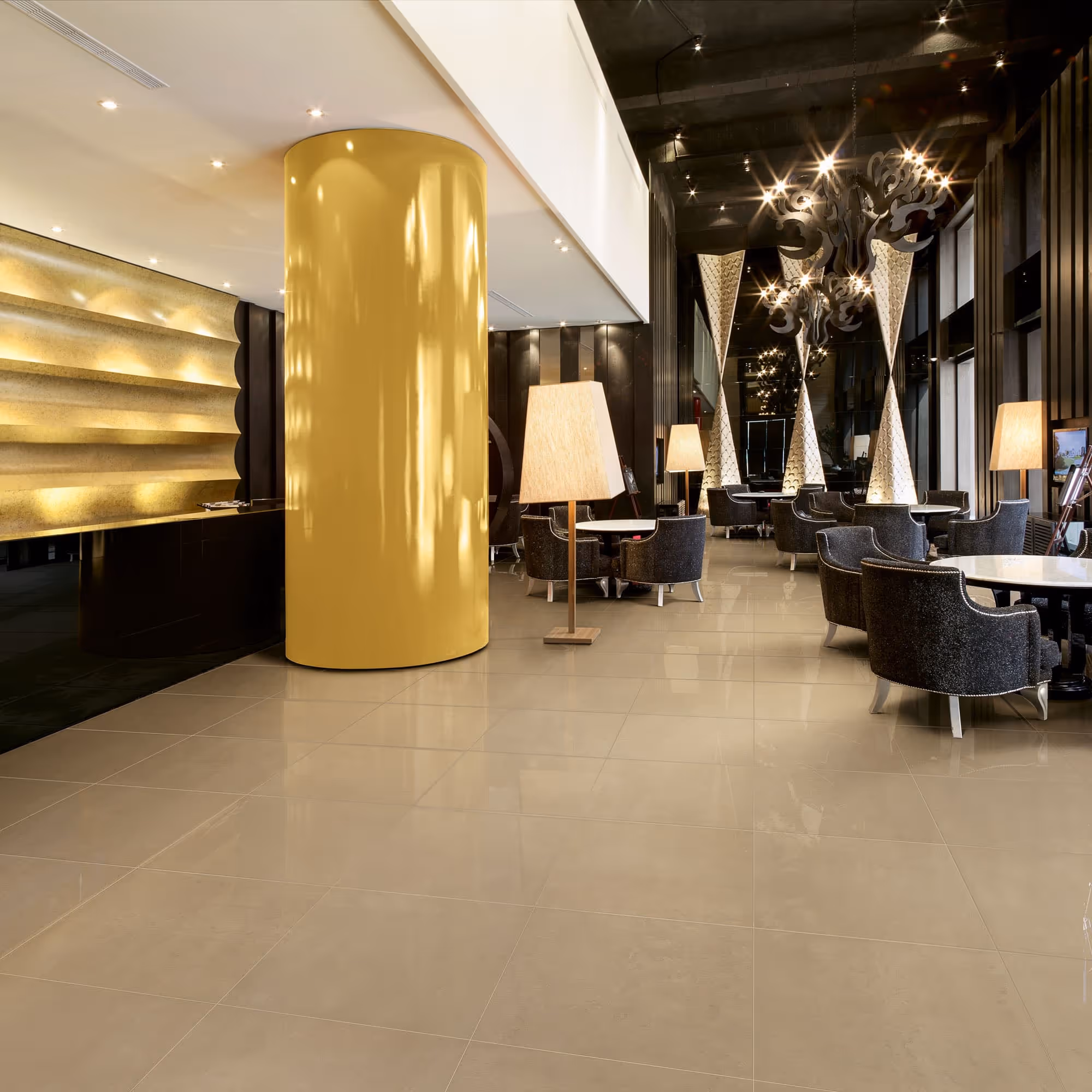 Modern hotel lobby with large yellow column, black chairs, white tables, and floor lamps.