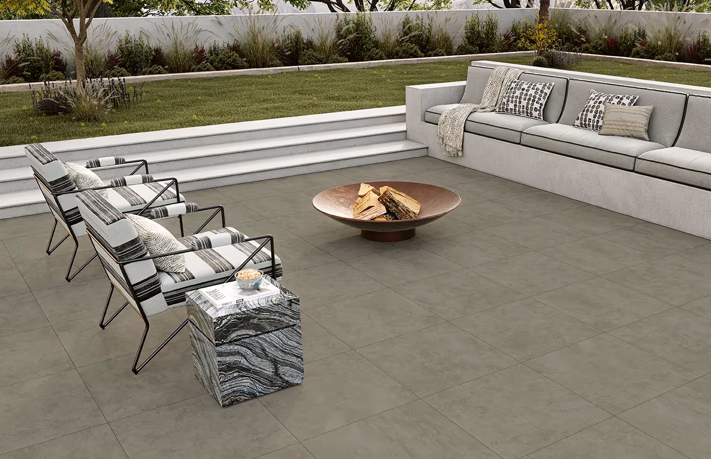 Outdoor patio with gray tiled floor, metal chairs with cushions, a fire pit, and a built-in corner sofa.