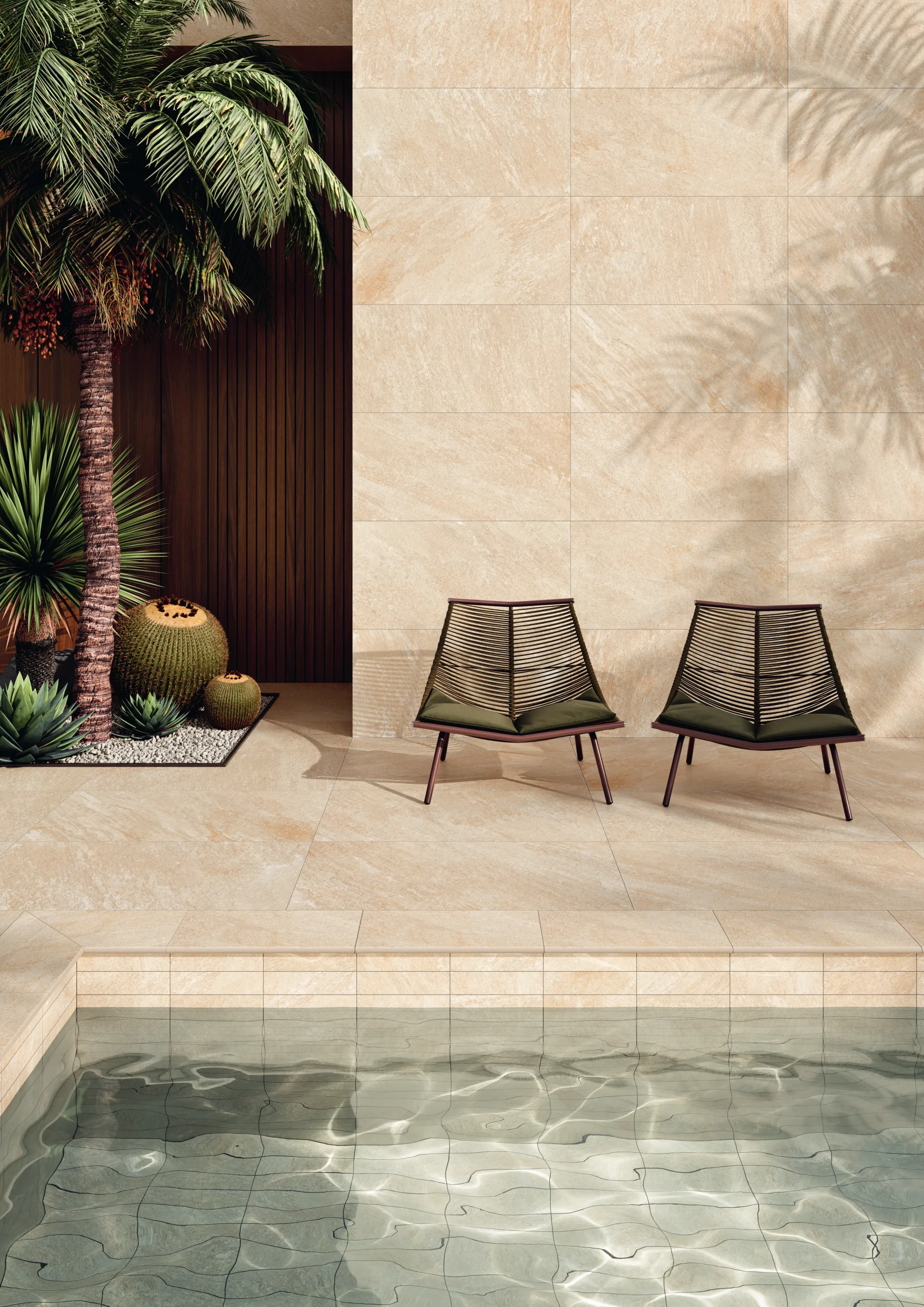 Two modern chairs on beige tiled patio beside reflecting pool and tropical plants near wooden door.