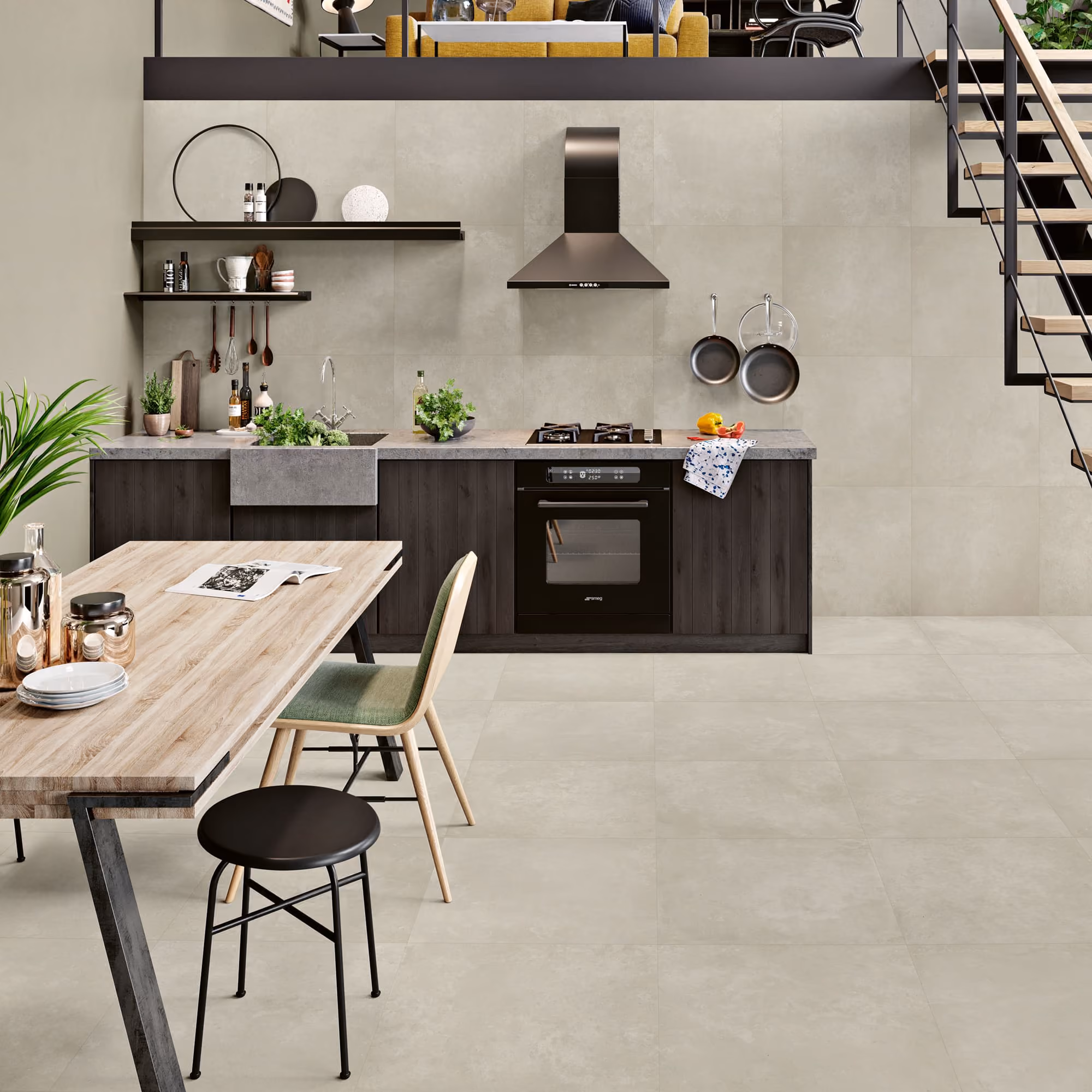 Modern kitchen with gray tiled floor and walls, wooden table, green chair, and black appliances.