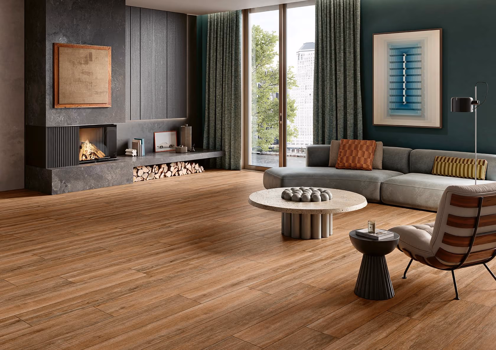 Modern living room with wooden floor, large gray sectional sofa, fireplace, and floor-to-ceiling windows.