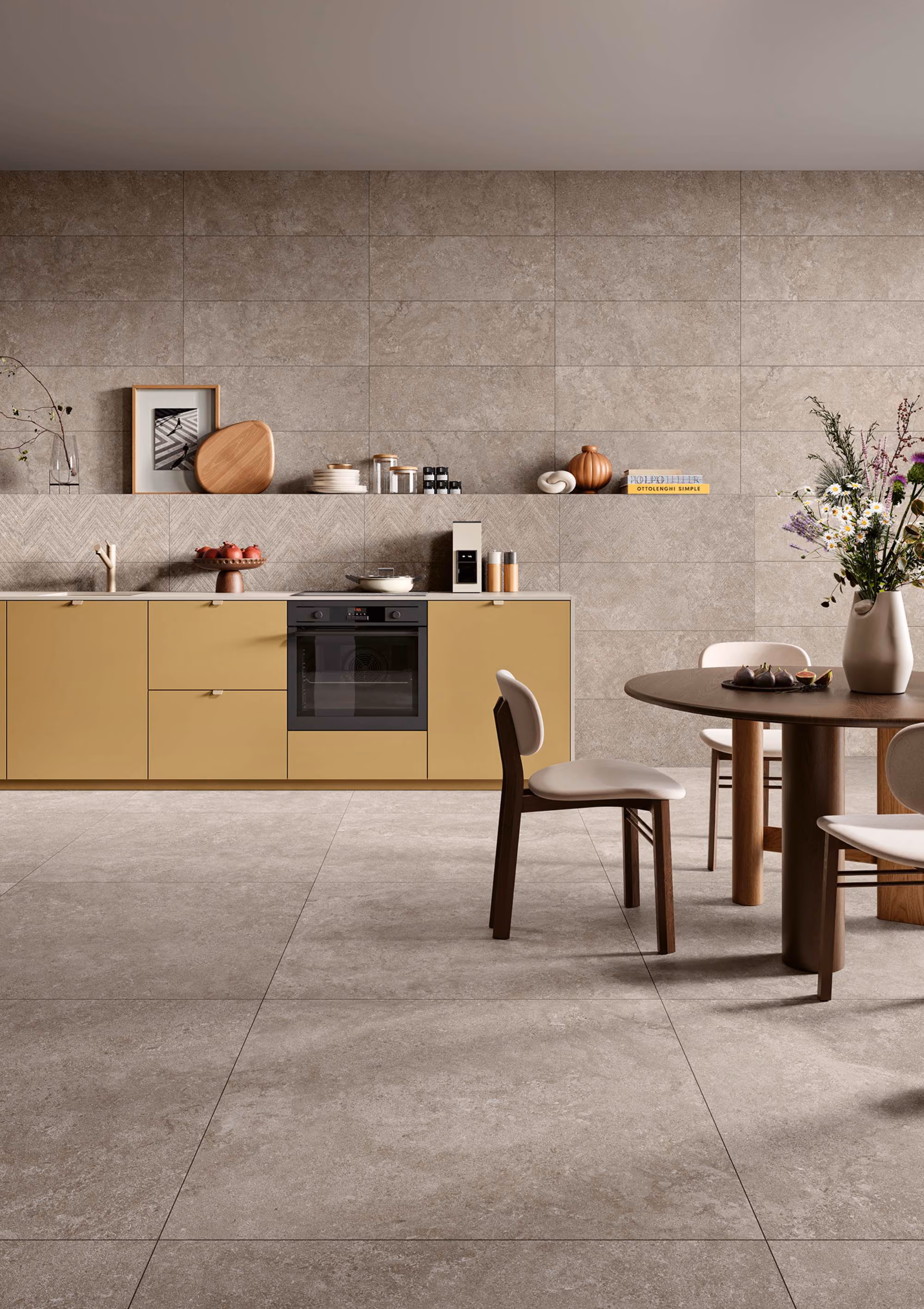 Modern kitchen with mustard cabinets, built-in oven, round wooden table, beige chairs, and flowers in a vase.