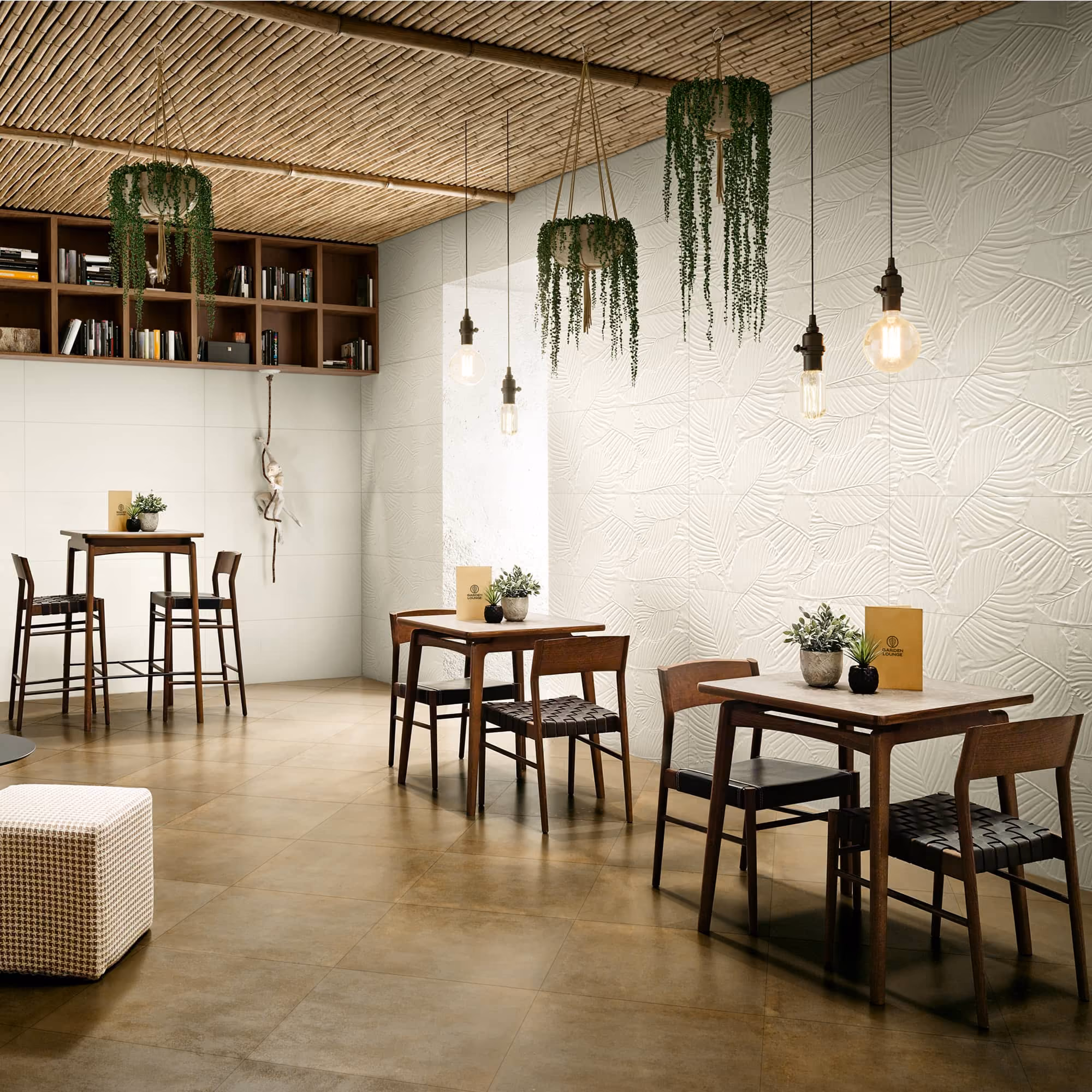 Modern cafe with wooden tables, chairs, hanging plants, pendant lights, and textured white wall.