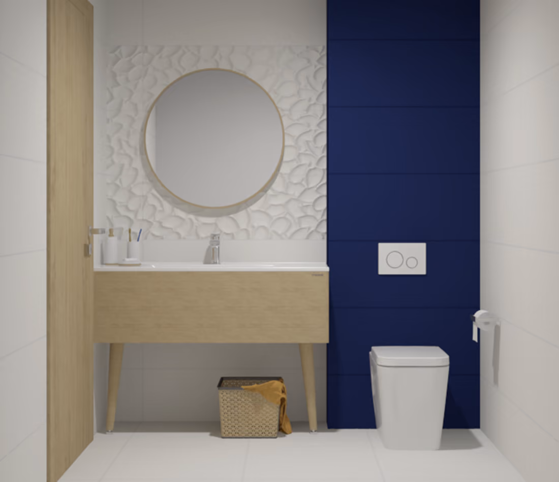 Modern bathroom with wood vanity, round mirror, blue accent wall, white toilet, and wicker basket with towel.