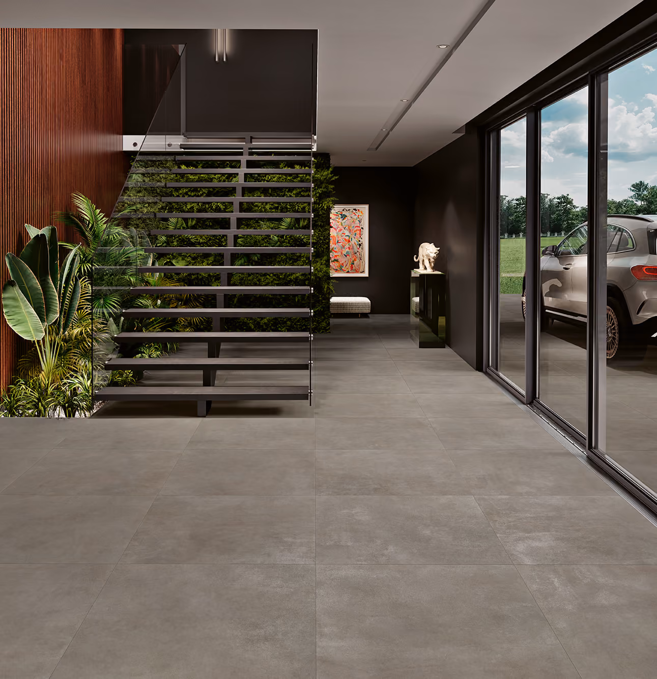 Modern interior with floating stairs, indoor plants, artwork, and a car visible through glass doors.