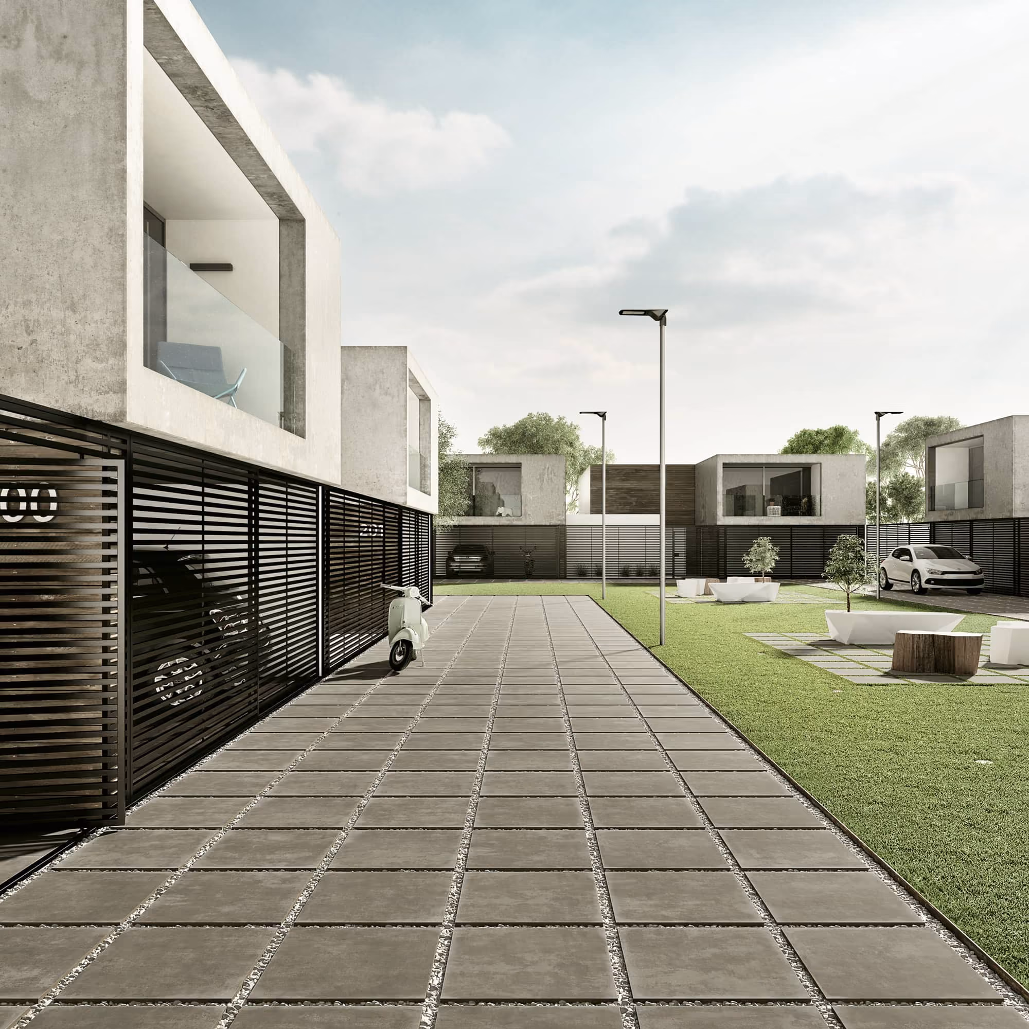 Modern residential area with concrete houses, paved walkway, green lawns, parked cars, and a scooter.