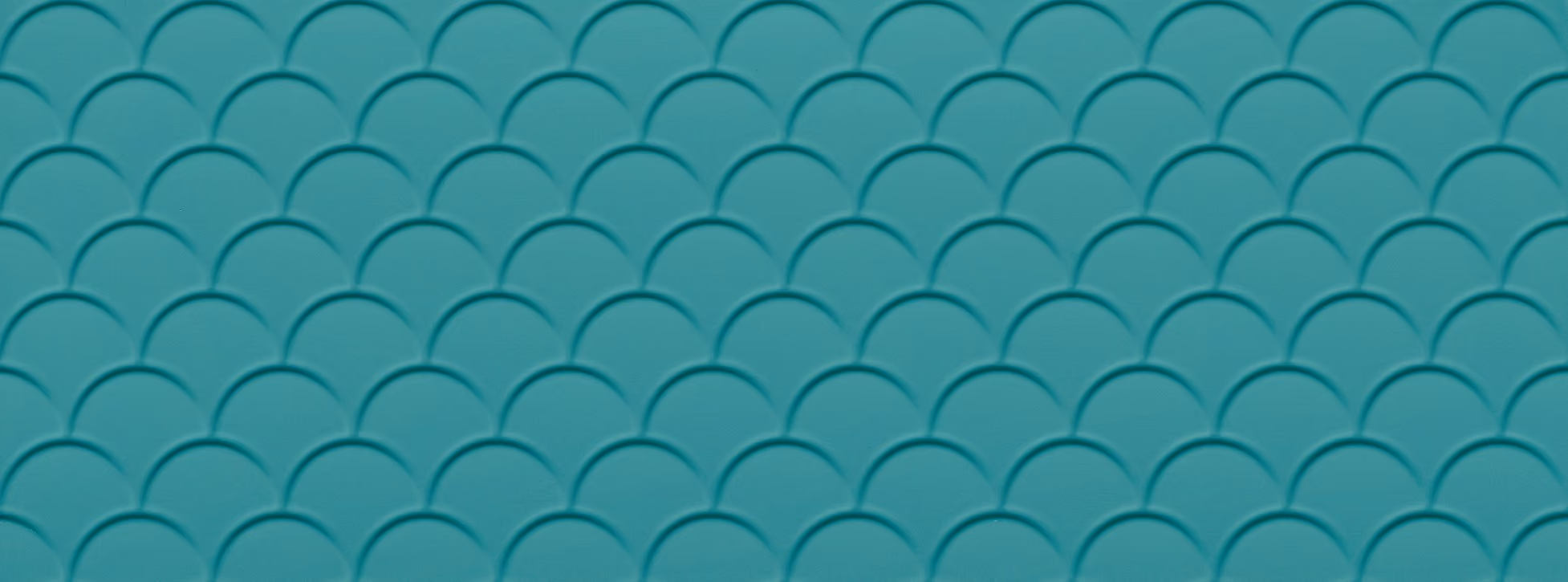 Close-up of a teal surface with a repeating embossed scallop pattern.