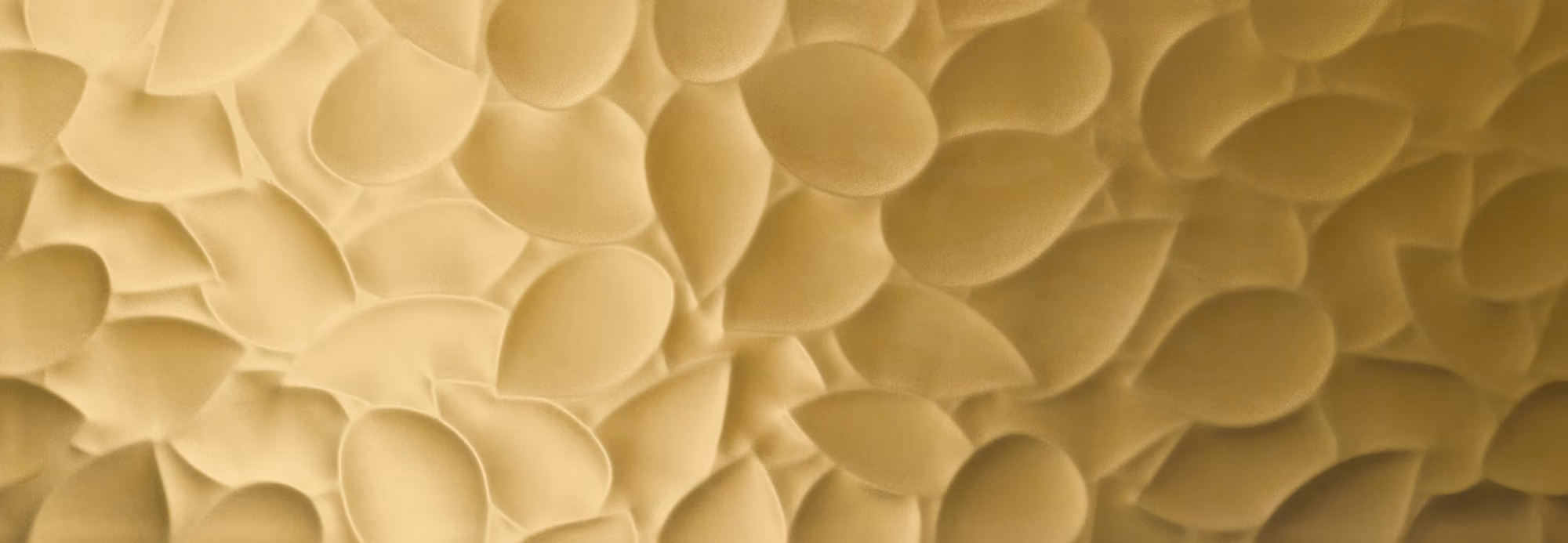 Close-up of overlapping, soft-textured gold leaf shapes forming a dense pattern.