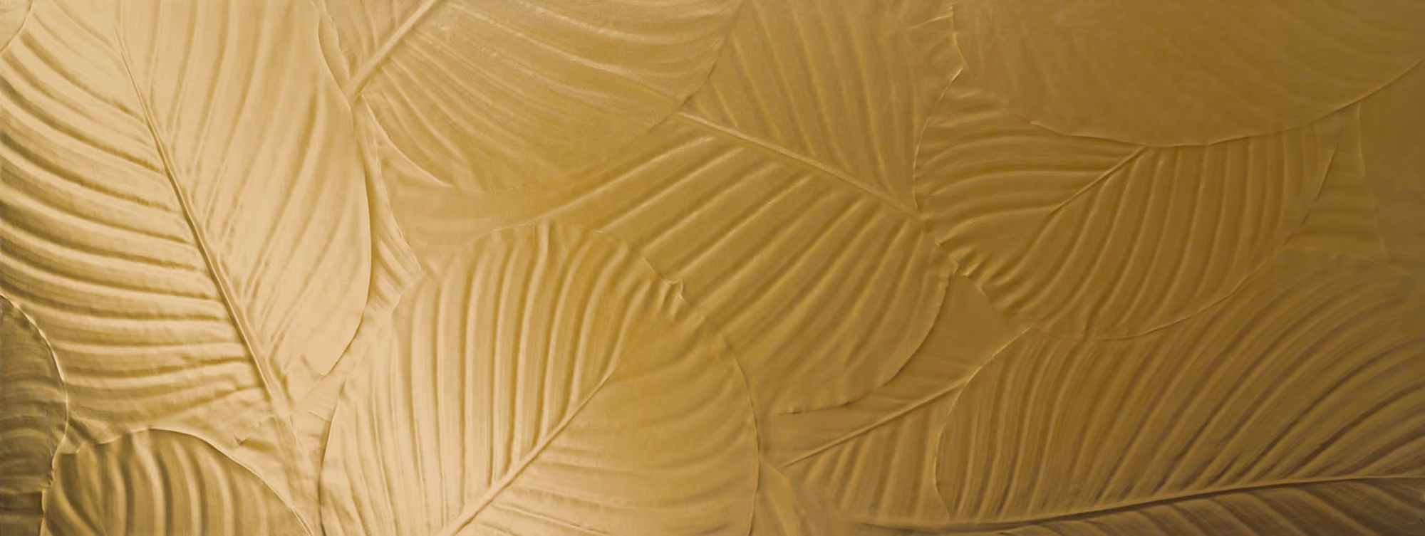 Close-up of large overlapping palm leaves with a gold texture and detailed veins.