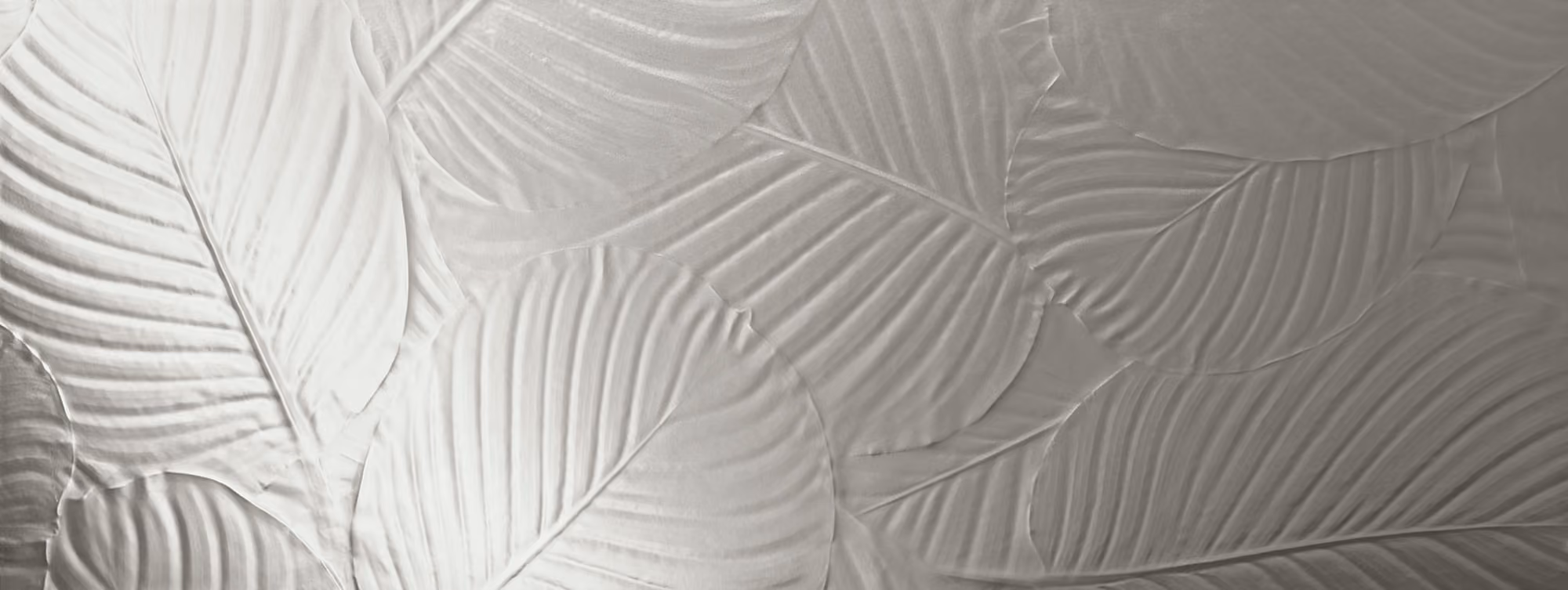 Close-up of textured wall with overlapping large leaves in silver-gray tones.
