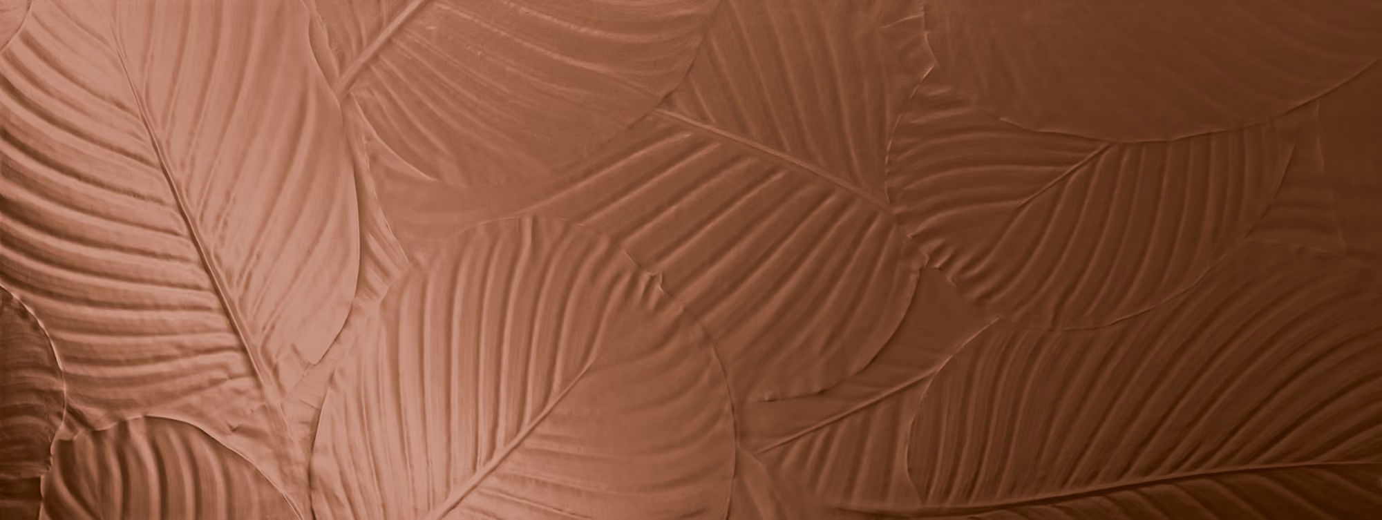 Close-up of leaves with embossed texture in copper tones overlapping each other.
