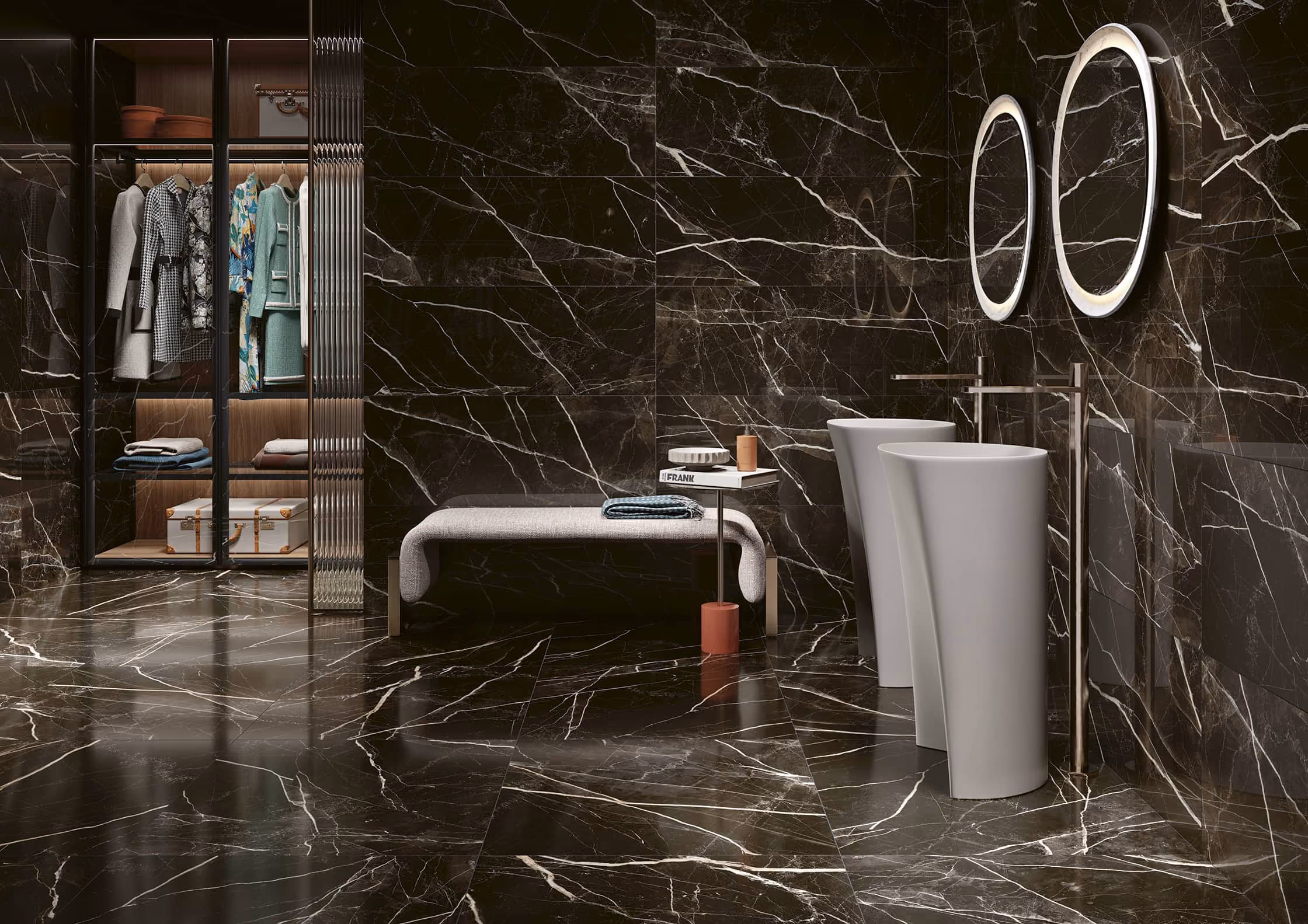 Modern bathroom with black marble walls and floors, two white pedestal sinks, and a glass closet.