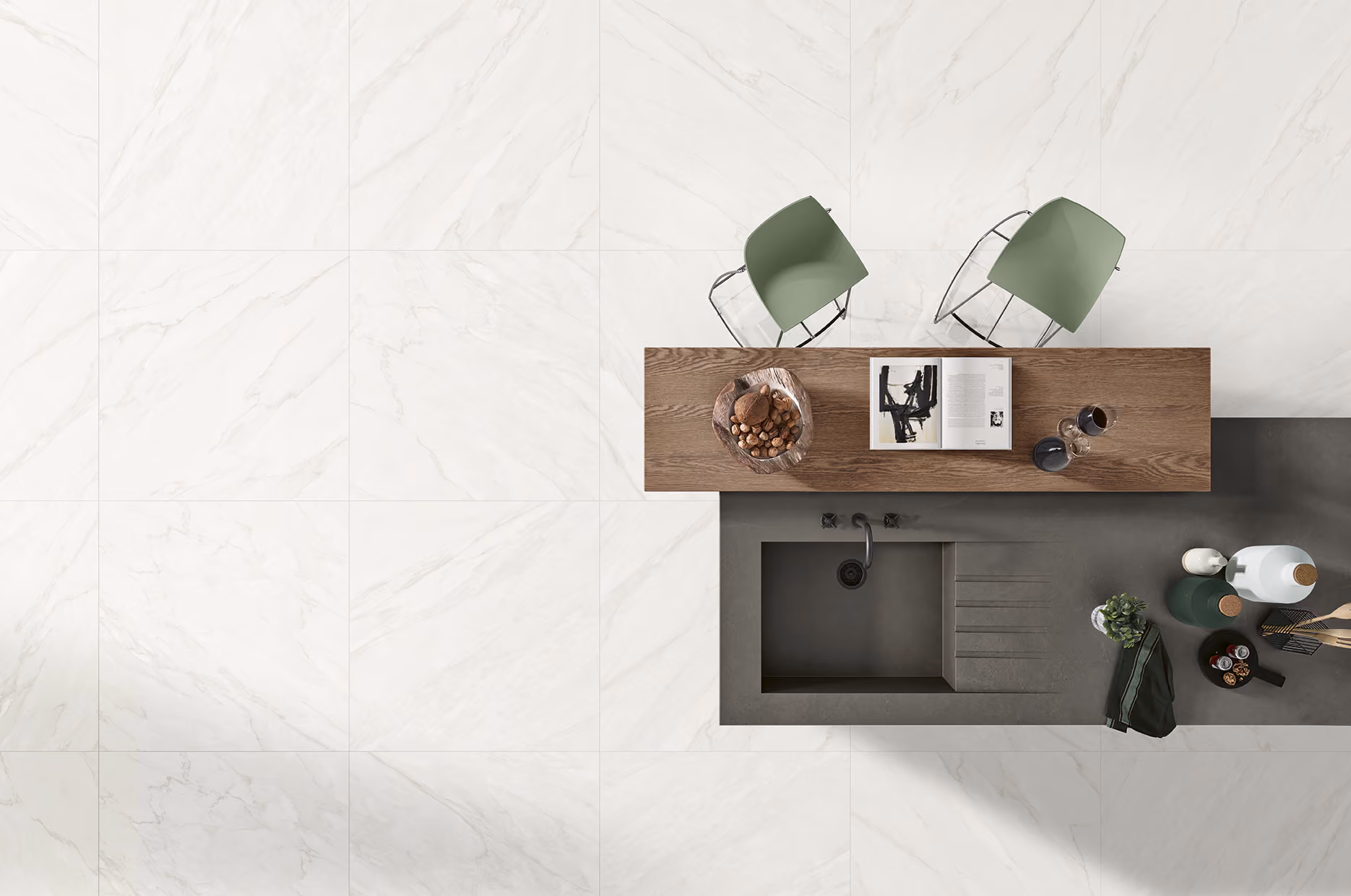 Top view of a modern kitchen with marble floor, gray sink, wooden countertop, green chairs.