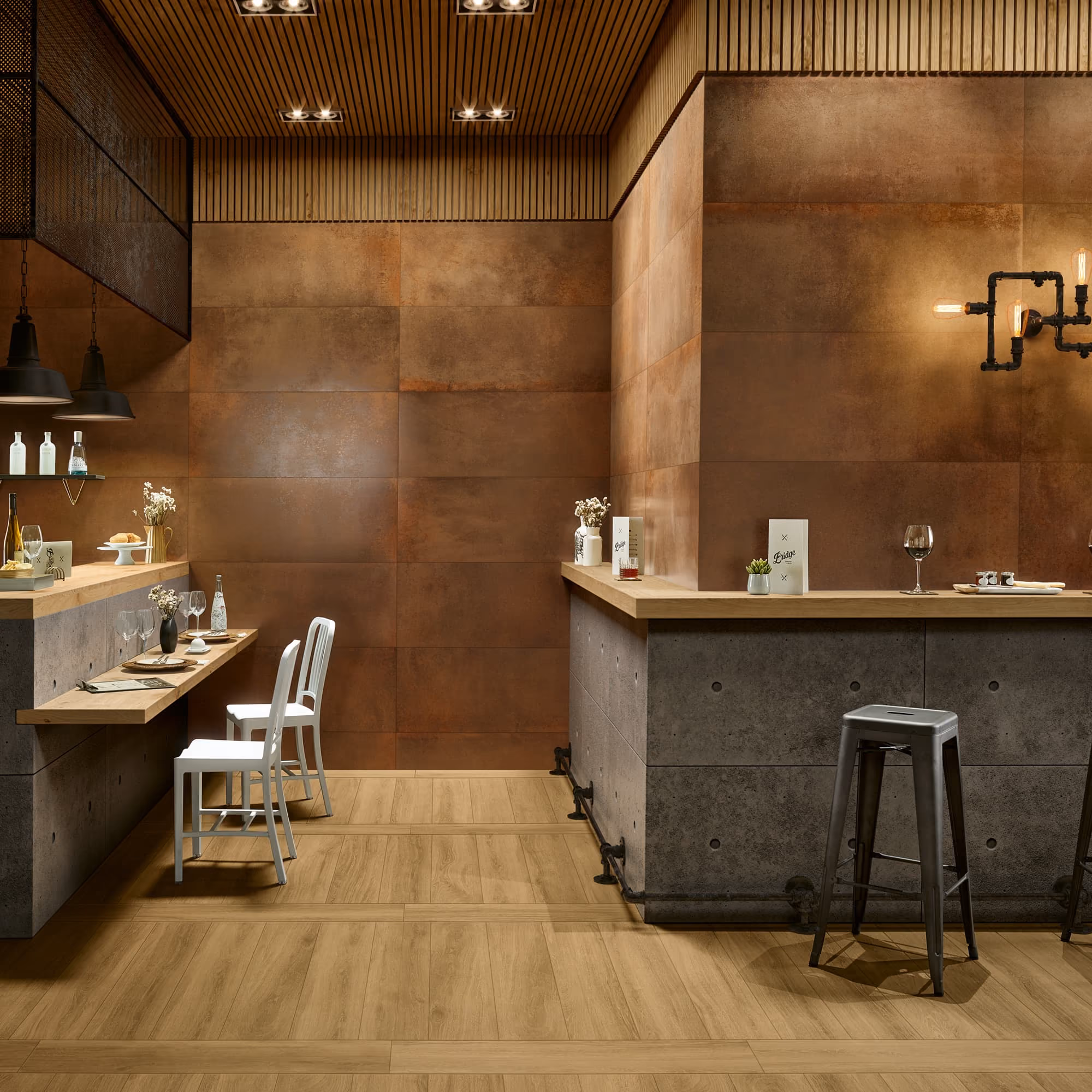 Modern café interior with wooden floors, industrial stools, and brown tiled walls under warm lighting.