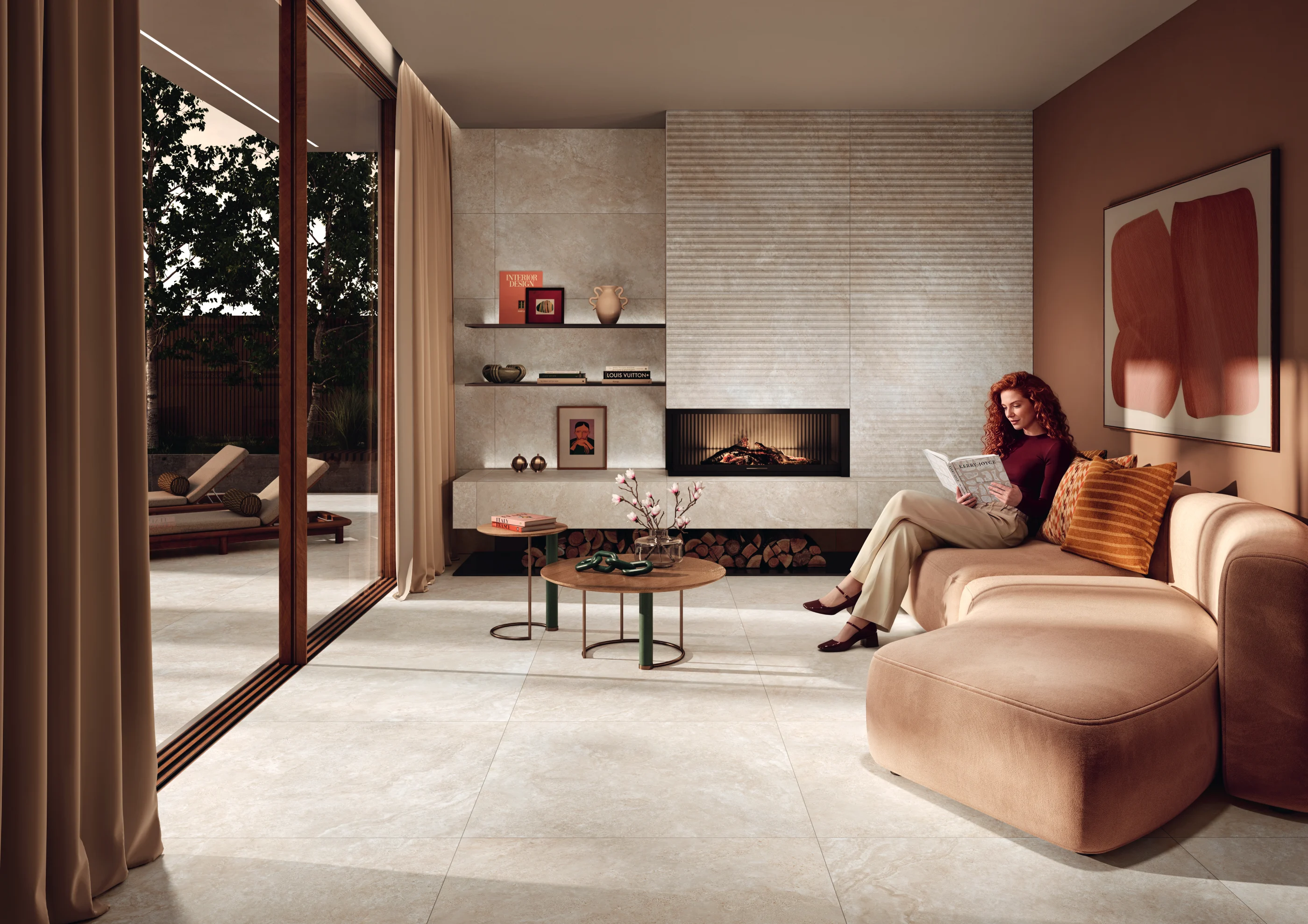 Woman reading magazine on beige sofa in modern living room with fireplace and glass doors to patio.