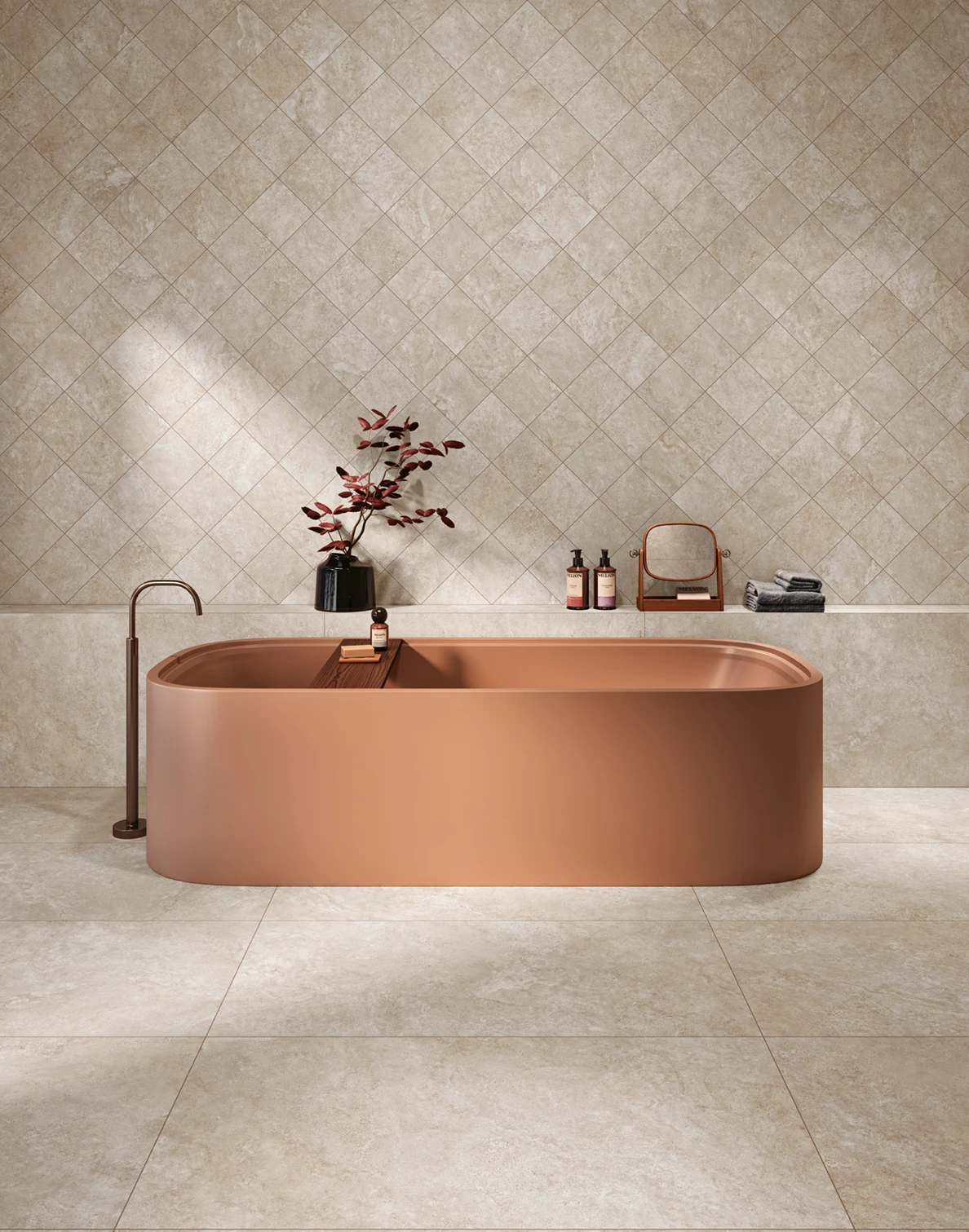 Modern beige bathroom with large blush pink freestanding tub and decoration on the tiled ledge.