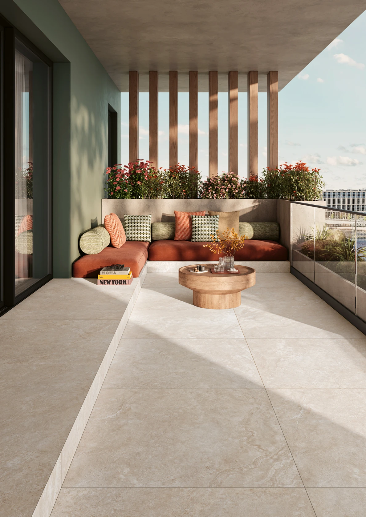 Modern outdoor patio with a corner sofa, cushions, round wooden coffee table, and flower planter.