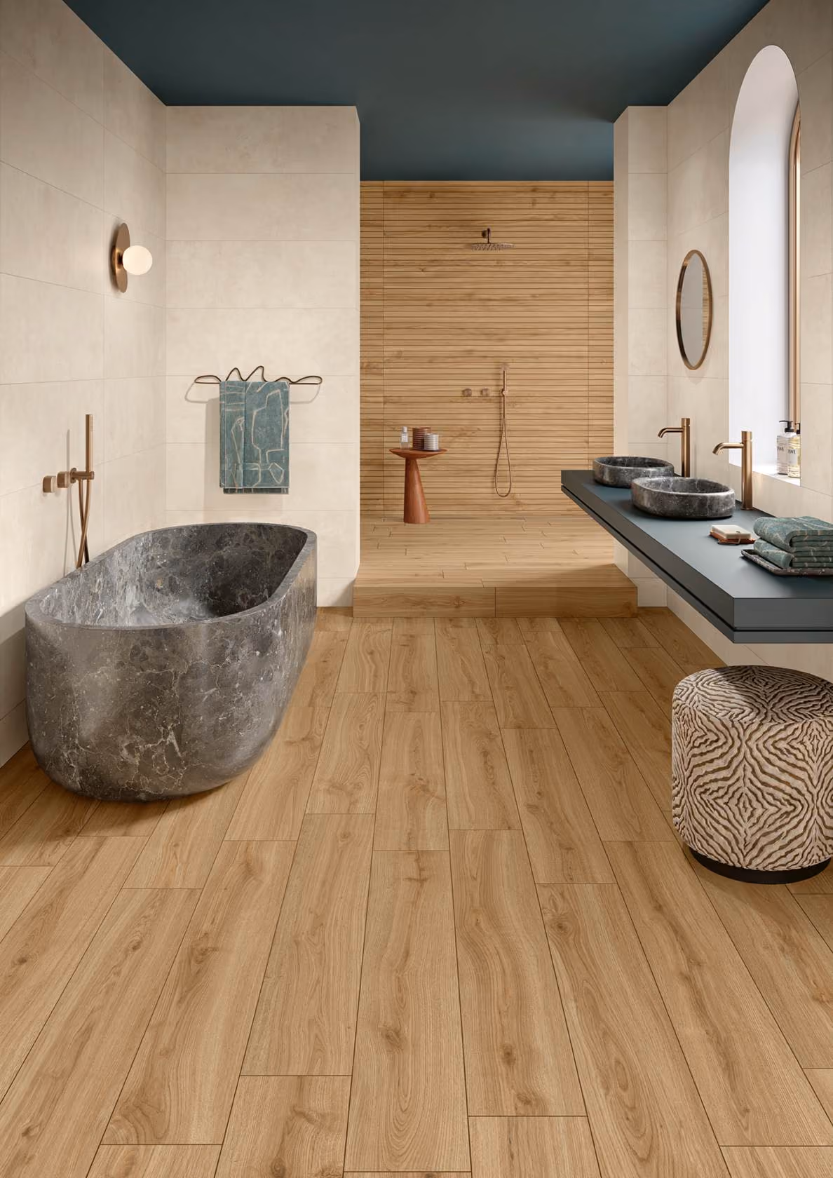 Modern bathroom with a stone bathtub, wood floor, wooden shower area, and double sinks with round mirrors.