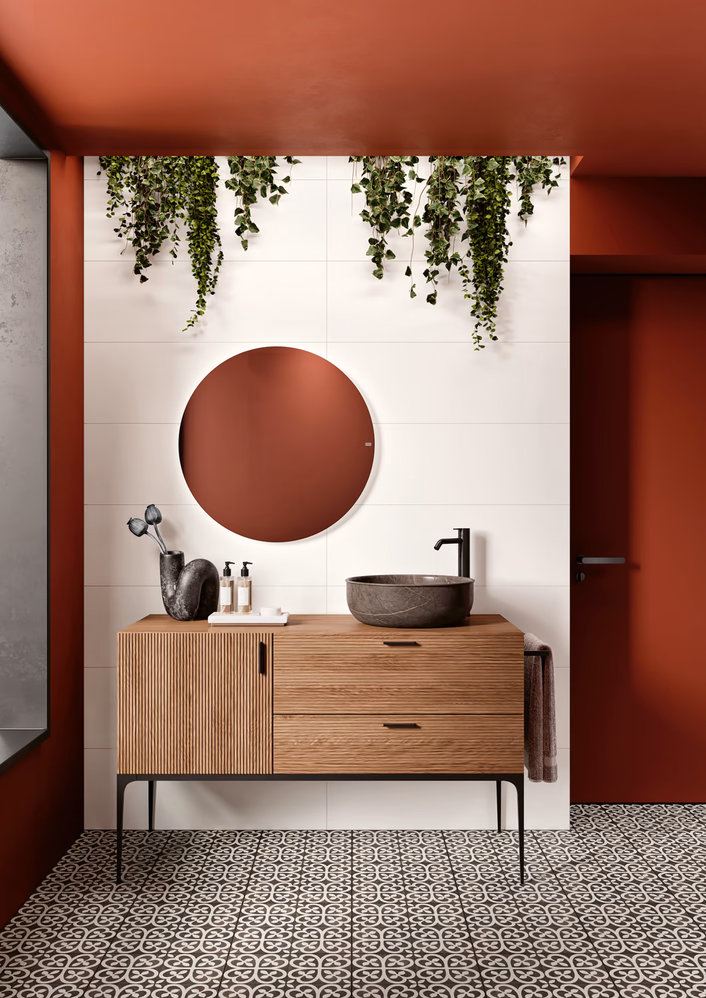 Modern bathroom vanity with wooden cabinet, round mirror, black sink, and hanging green plants.