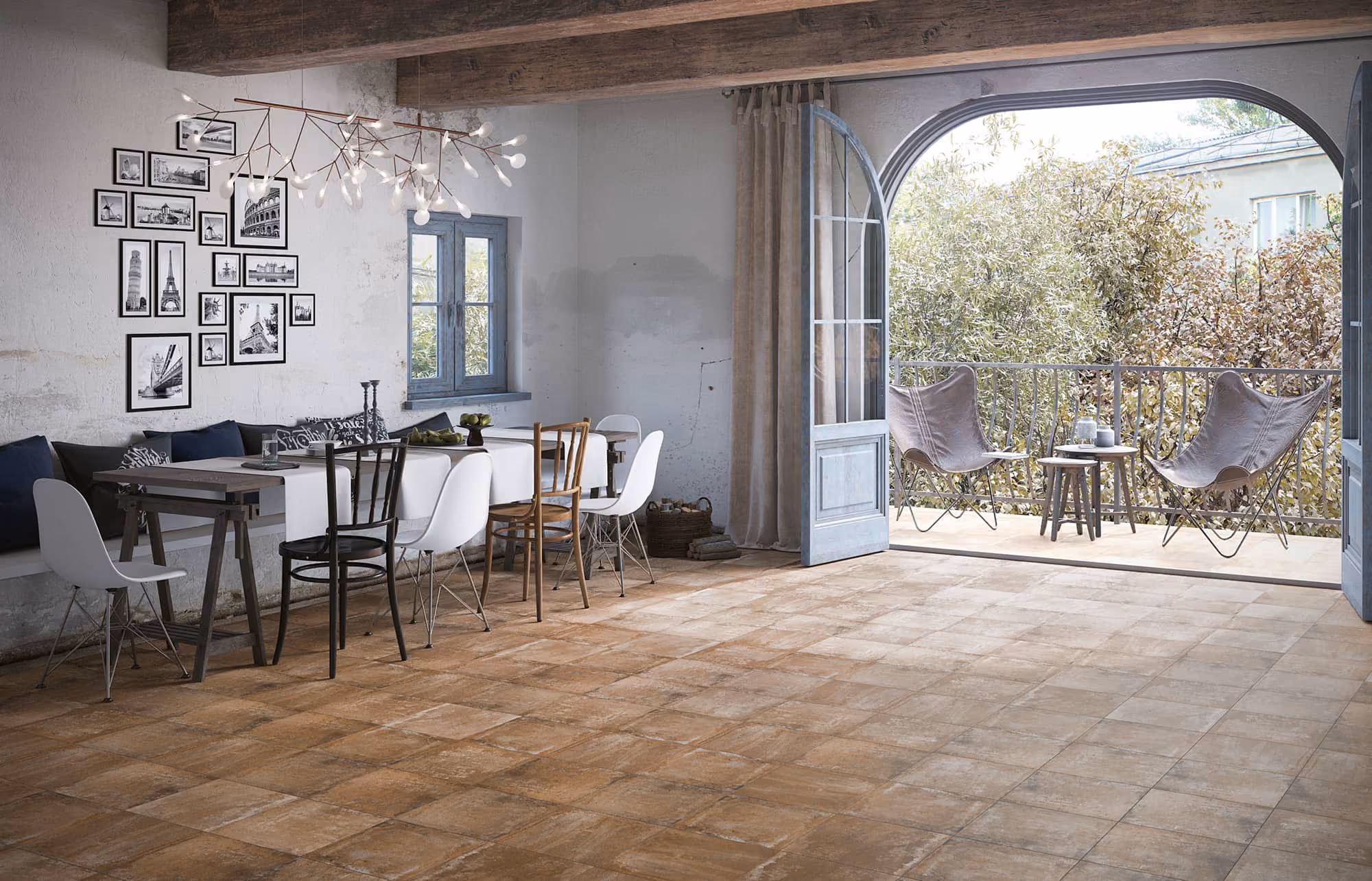 Rustic dining room with a mix of chairs, black and white photos, and a balcony with two butterfly chairs.