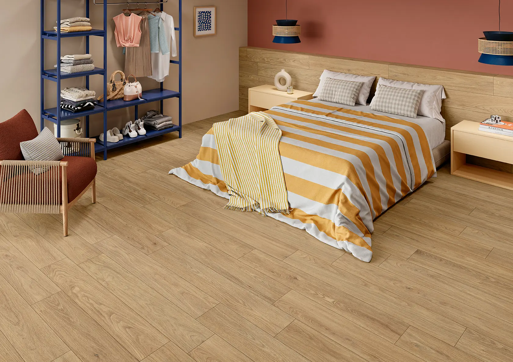 Modern bedroom with wood flooring, bed with striped bedding, armchair, and open closet with clothes.