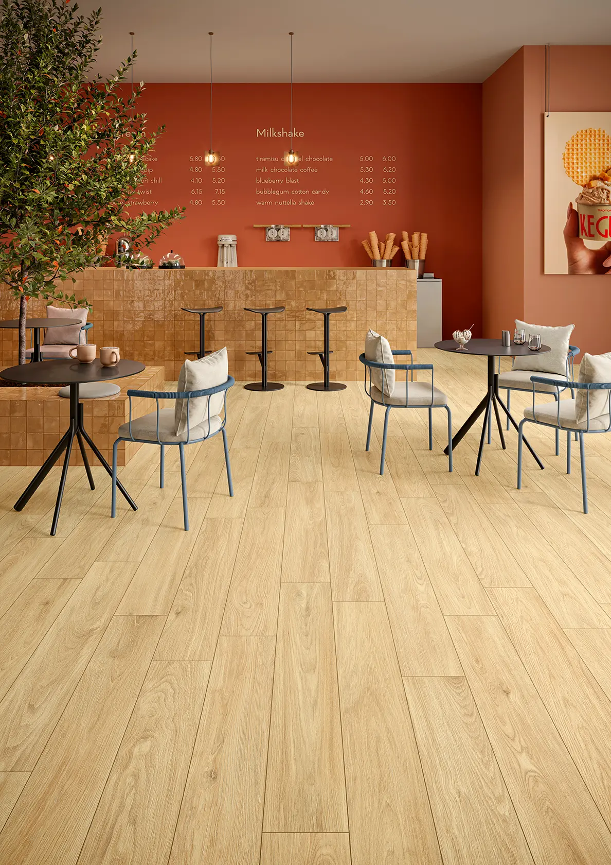 Modern cafe interior with light wood floor, black tables, chairs with cushions, and orange walls.