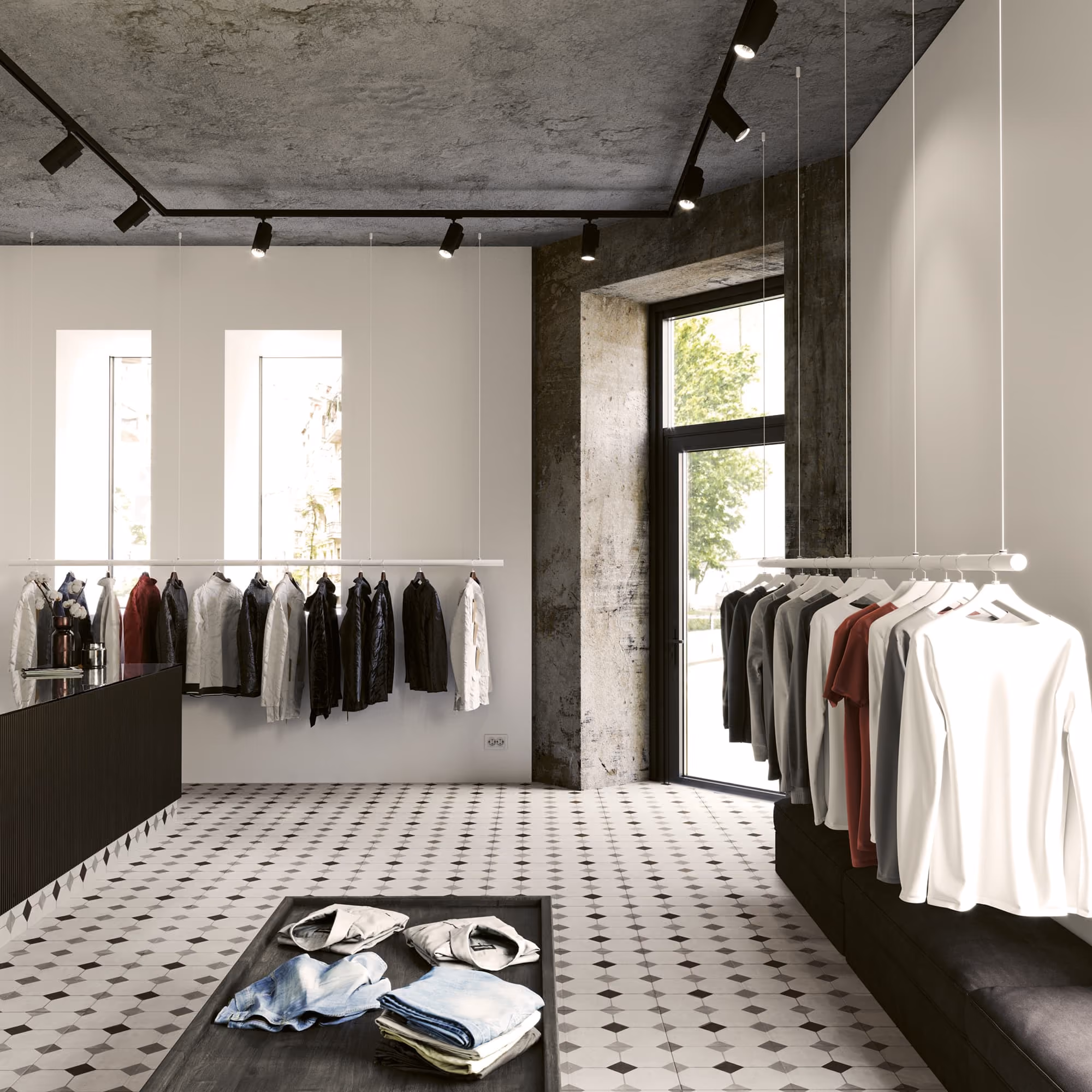 Modern clothing store interior with jackets and shirts hanging and folded clothes on a table near windows.