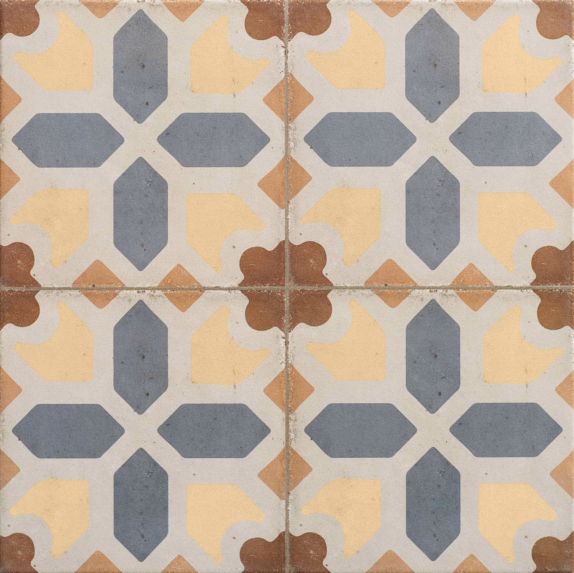 Four vintage-style tiles with blue cross and yellow, brown ornamental shapes forming a repeating pattern.