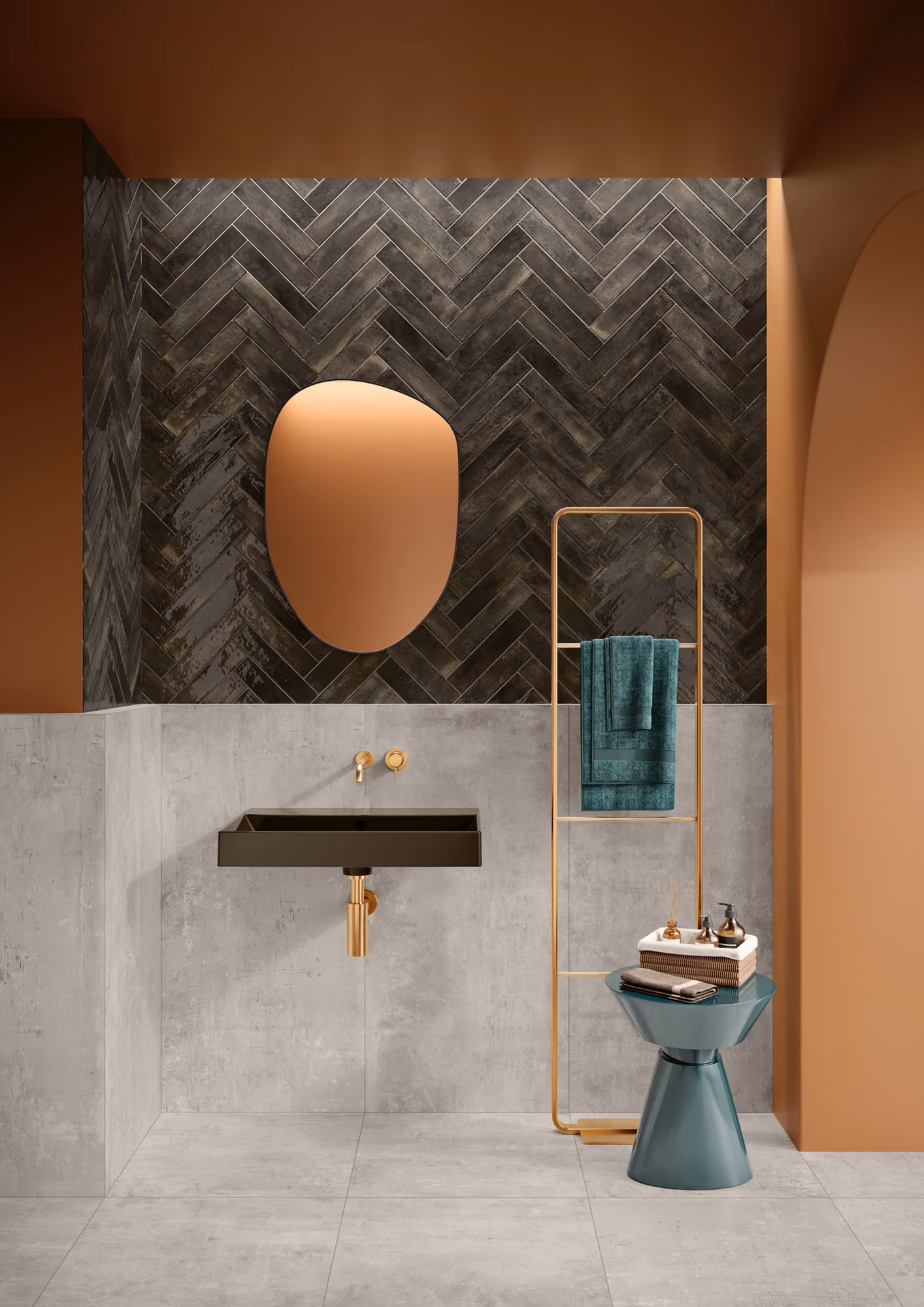 Modern bathroom with black sink, gold fixtures, irregular mirror, and teal towel on gold rack.