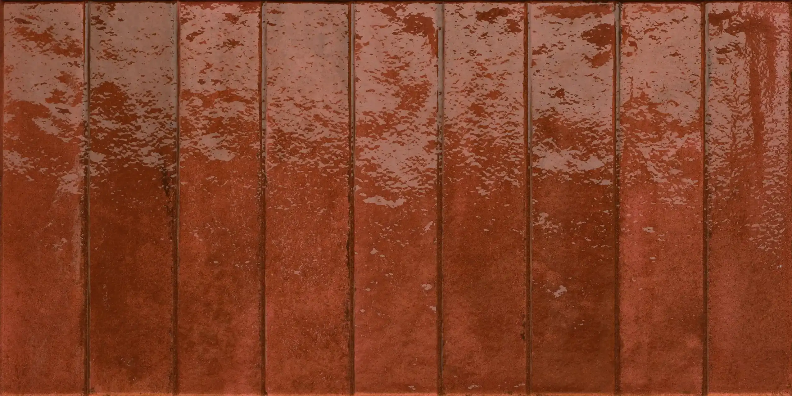 Glossy rectangular reddish-brown ceramic tiles arranged vertically with slight color and texture variations.