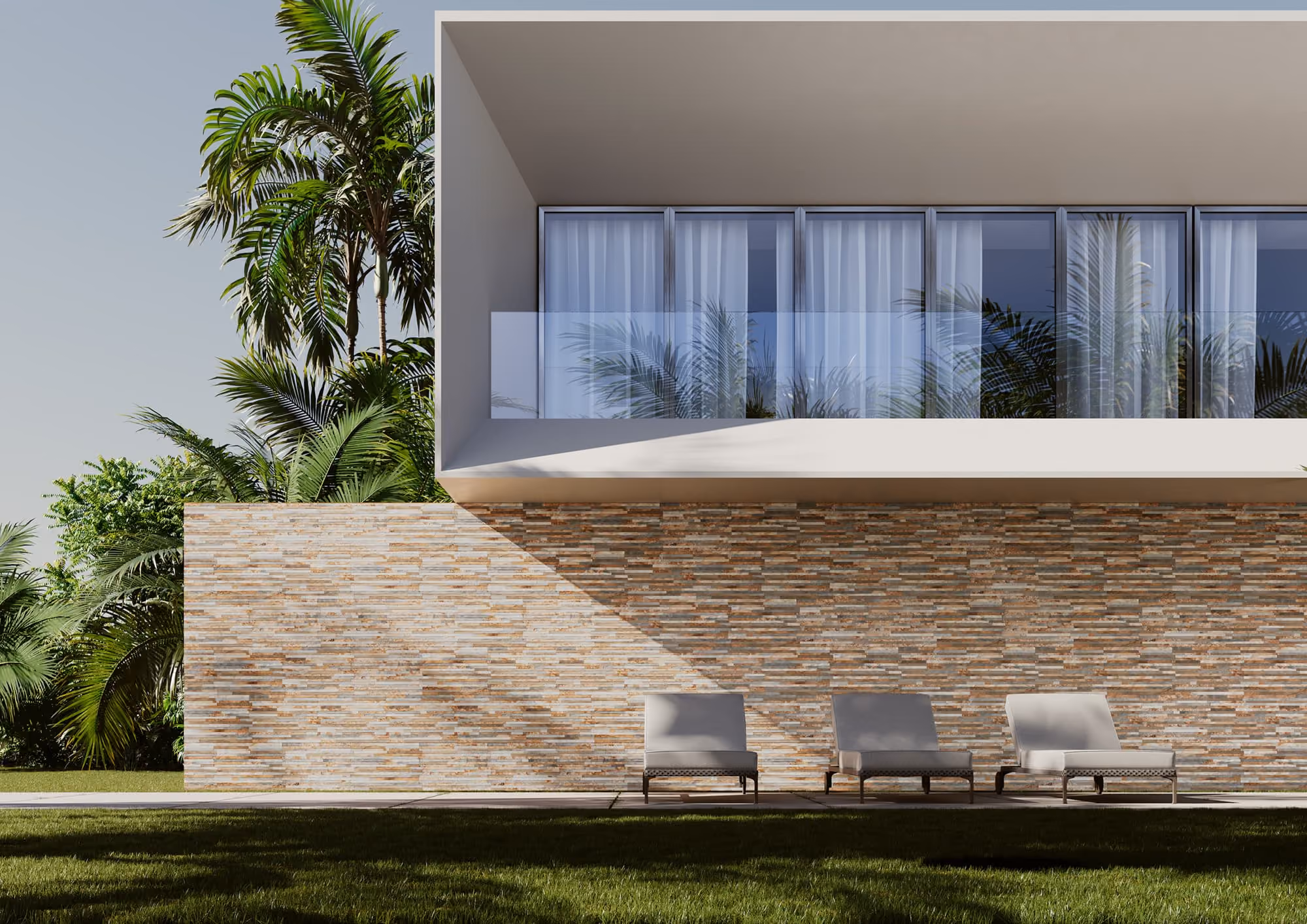 Modern house with large windows, stone wall, patio chairs, and tropical plants outdoors.