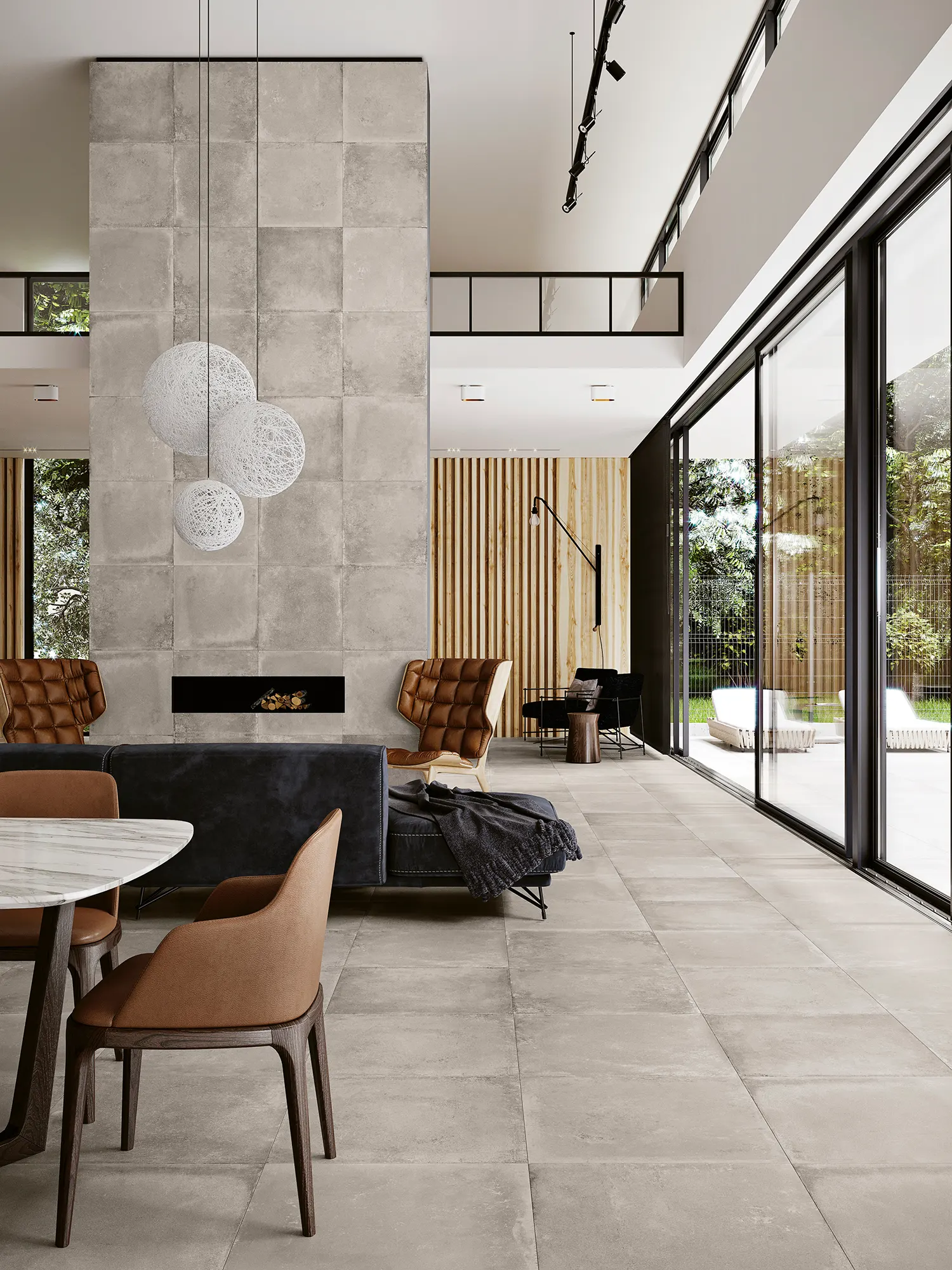 Modern living room with large glass windows, tiled floor, pendant lights, brown and black chairs.
