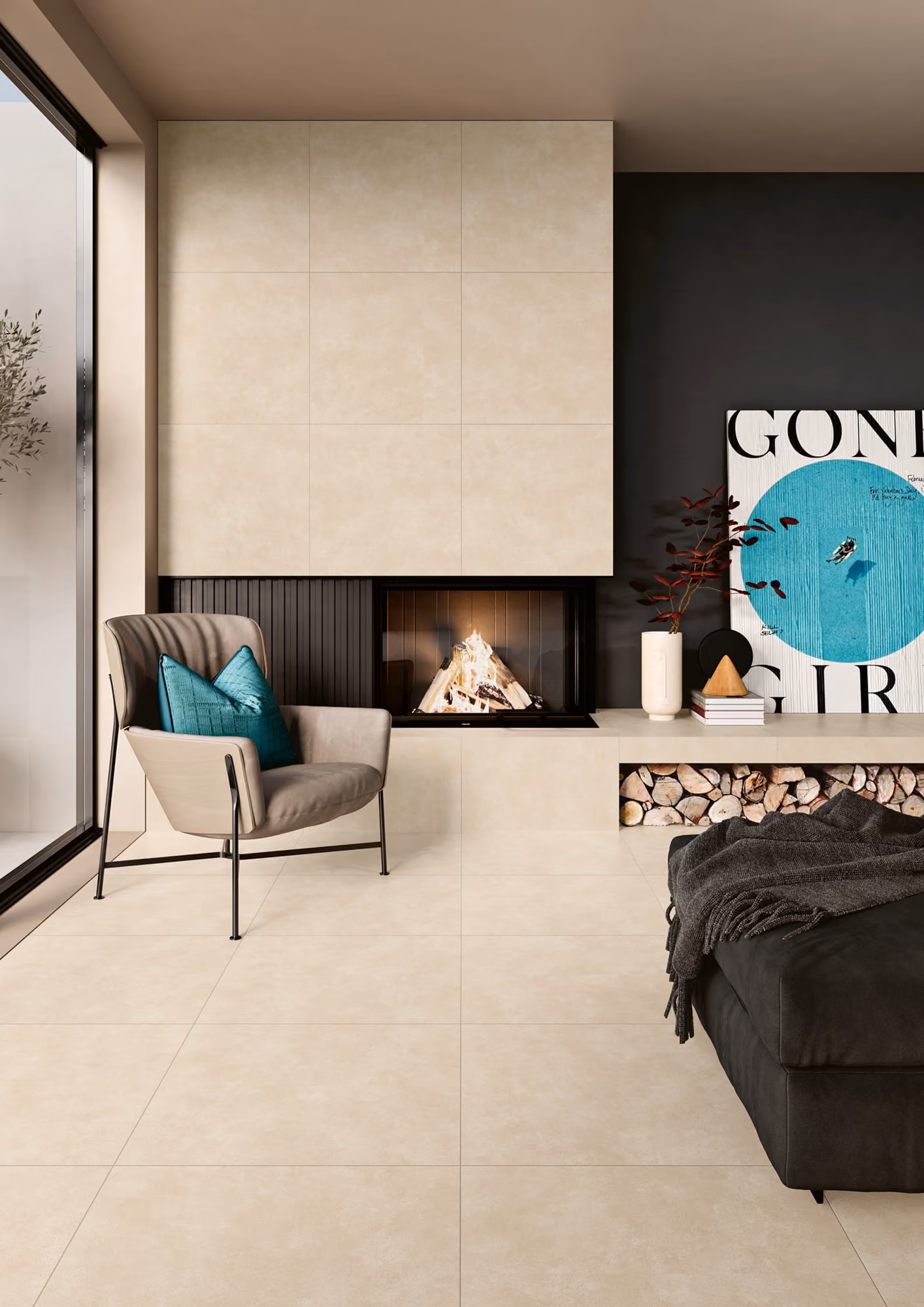Modern living room with beige tiled fireplace, gray armchair with teal pillows, and black couch with blanket.