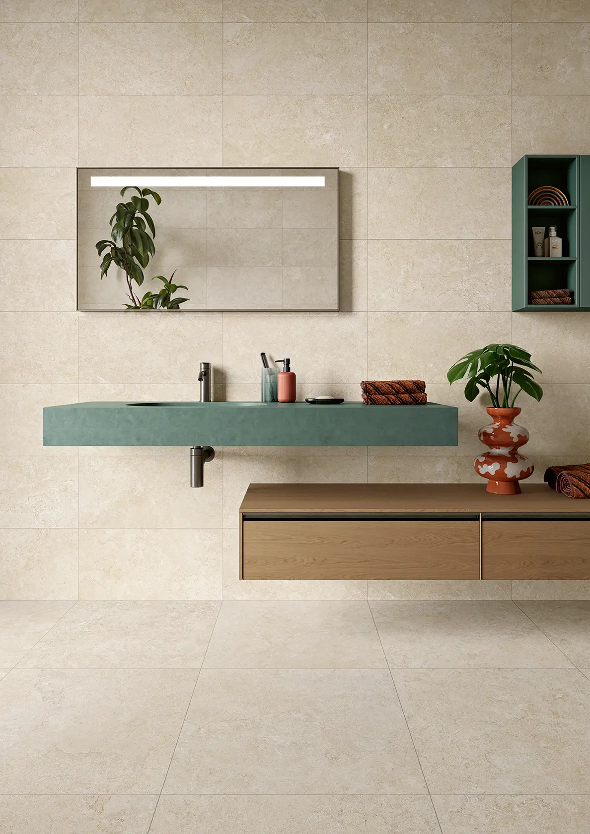 Modern bathroom with beige stone tiles, green floating sink, wooden cabinet, plants, and wall mirror.